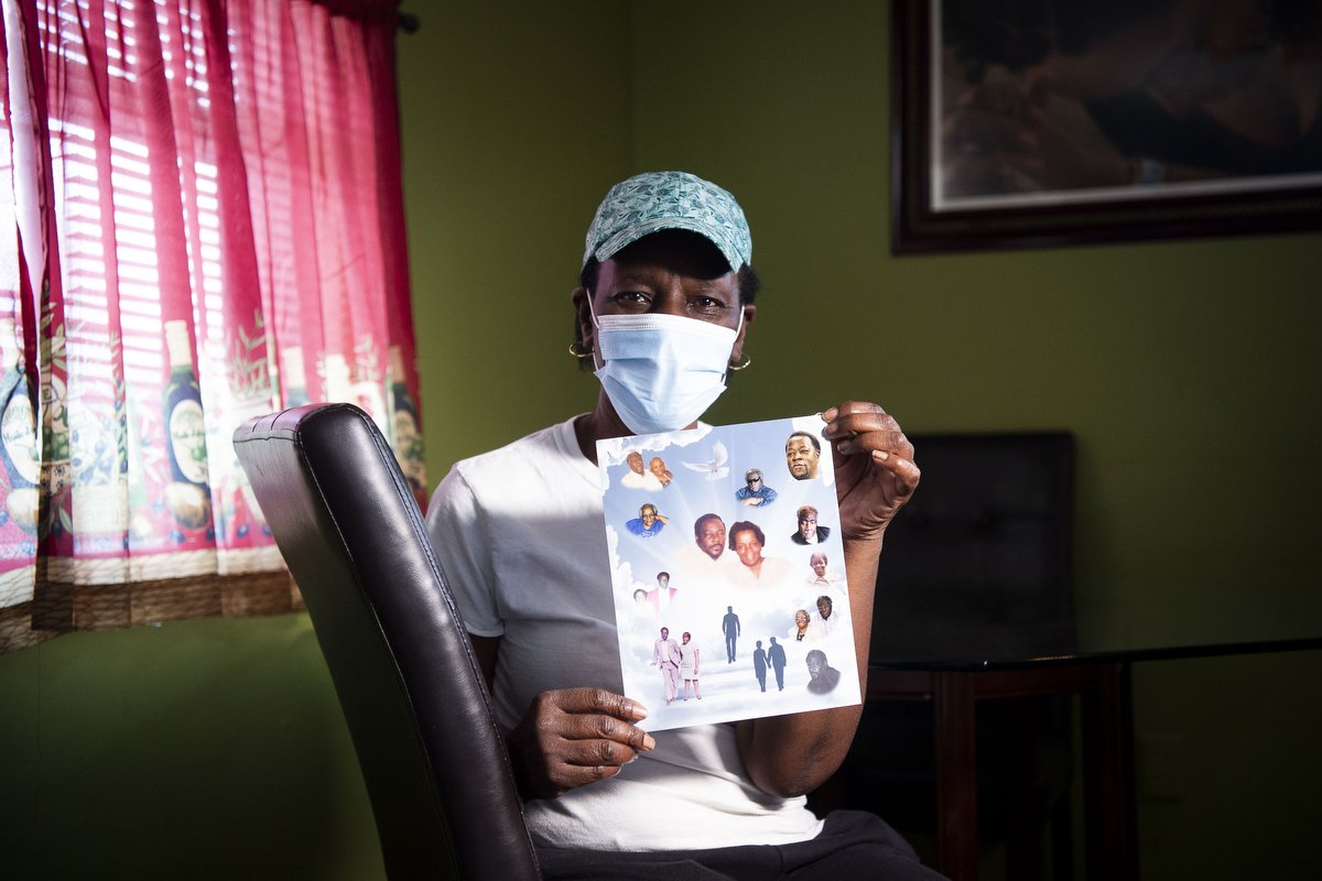  Callister Vernon poses for a portrait holding a memorial photograph of loved ones in her home in Knoxville, Tenn. on Wednesday, March 24, 2021. Vernon lost her mother, father and older brother to COVID-19 last July in the space of two weeks. 