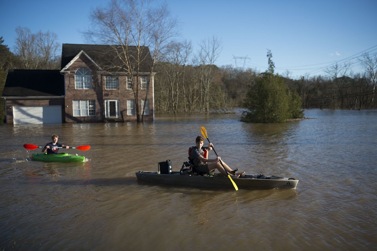  Truman Douglass and James Webster, both from Knoxville, pass by a flooded home next to the Sunoco on Ebenezer Road and Gleason Drive in Knoxville in February  2019. 