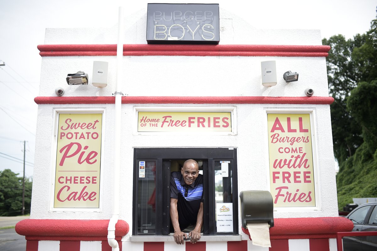  Andre Bryant, owner of Burger Boys, peeks out of the service window of the restaurant's patio on Chapman Highway in South Knoxville. When a bag of food goes out the window,  Bryant has all the confidence in the world. "Every time I deliver that burg