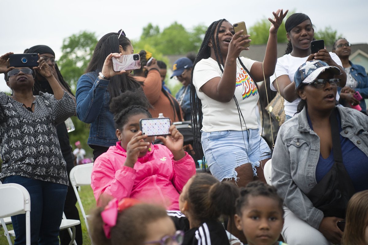  Community members sing along as Niya Goins, who performs under the name Niya G from Tennessee, performs in a talent showcase at a M.O.V.E in L.O.V.E rally at Lonsdale Homes. 