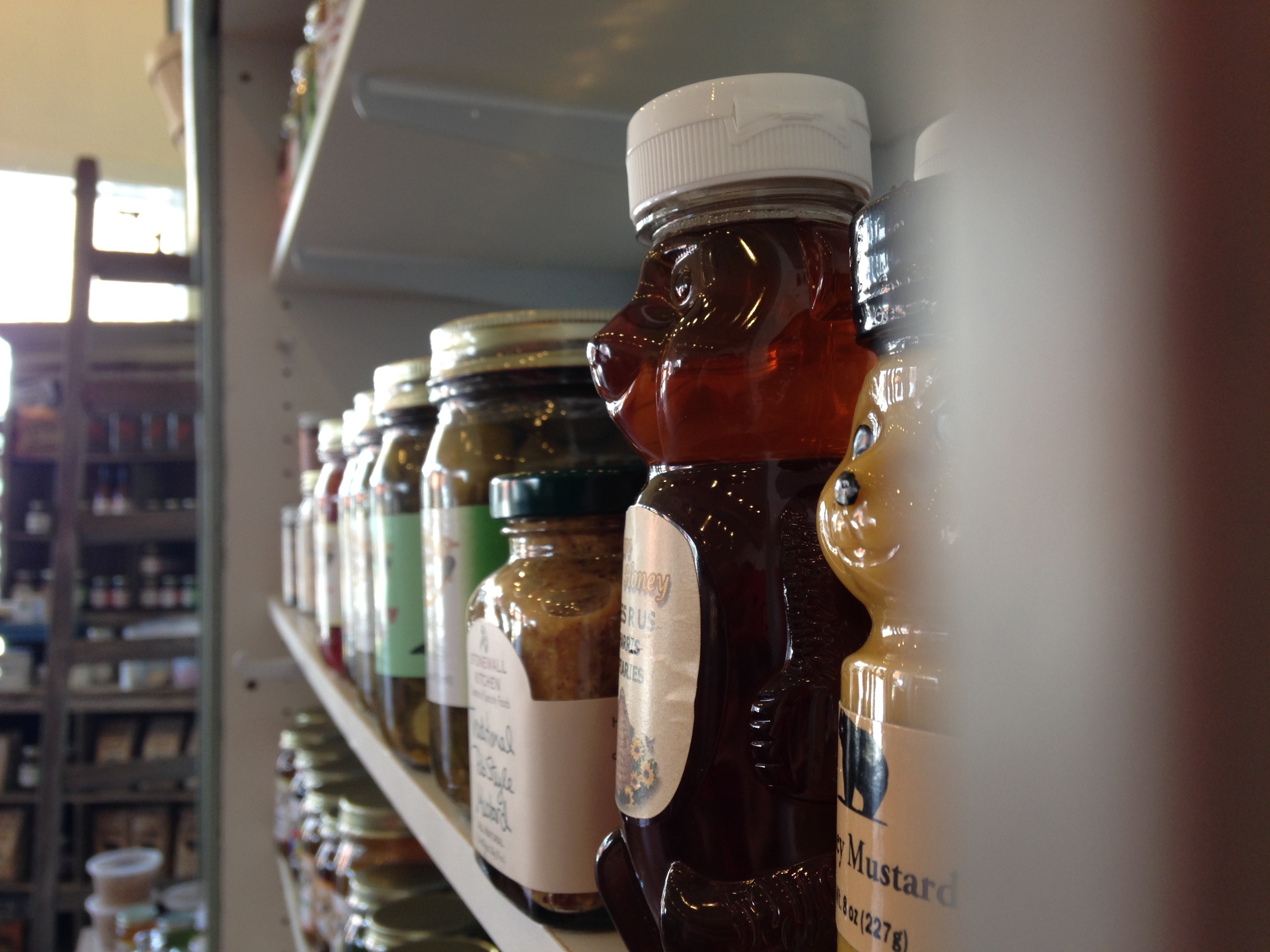 Local honey, condiments and preserves line the rustic wood shelves.