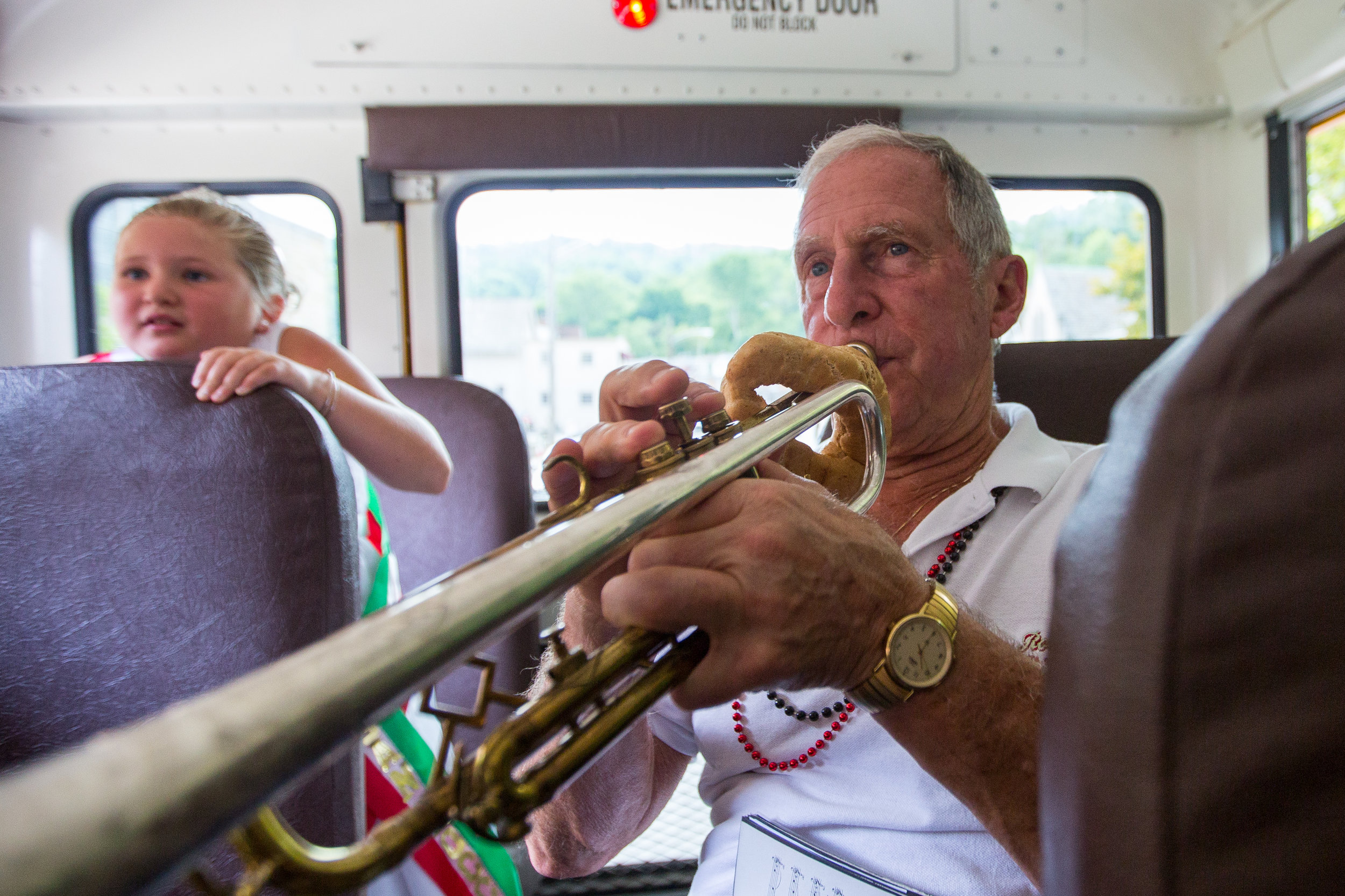  Henry Bufalini plays his trumpet in a school bus with other members of the San Rocco Festa Band as they drive from St. Titus Church to the beginning of the procession route on Sunday morning in Aliquippa. Thousands of people participated in the proc