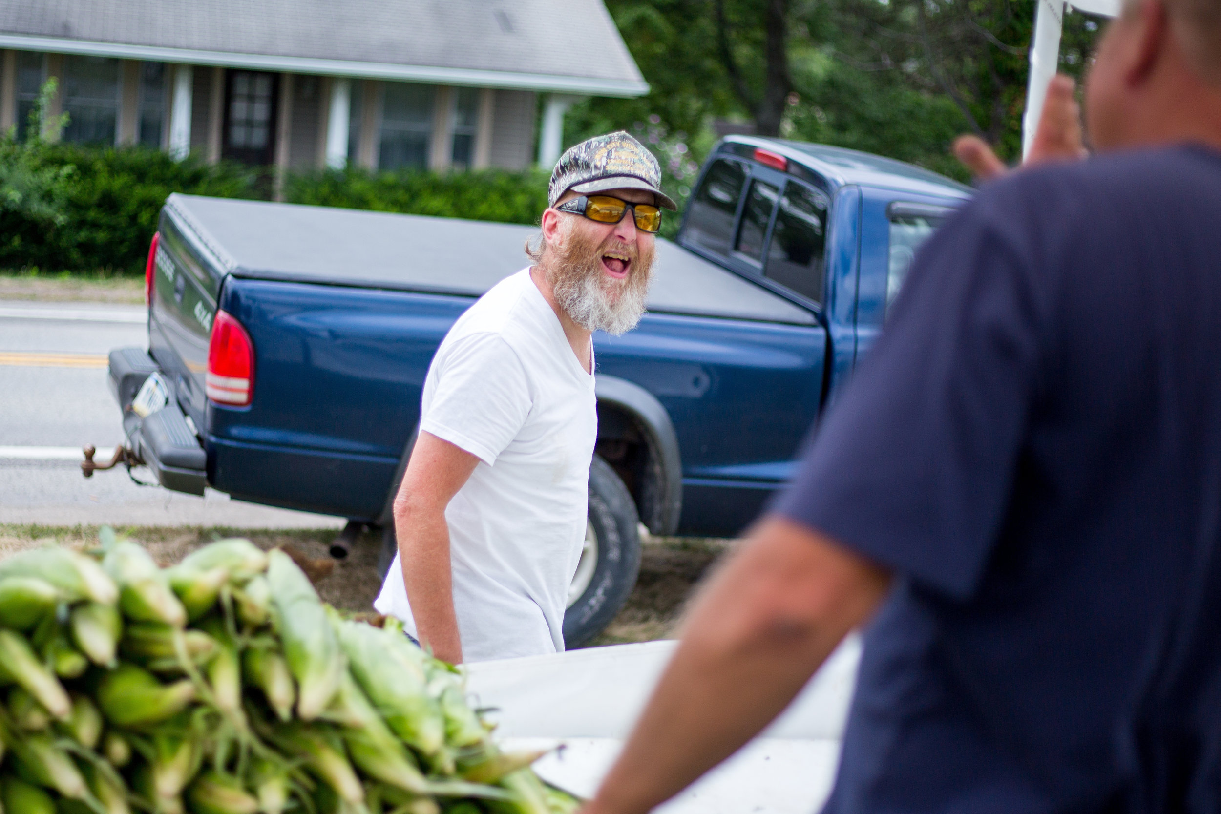  Doug Aiken, left, laughs after getting corn from Mike Wise at his produce stand on Highway 65 in North Sewickley on Tuesday afternoon.  