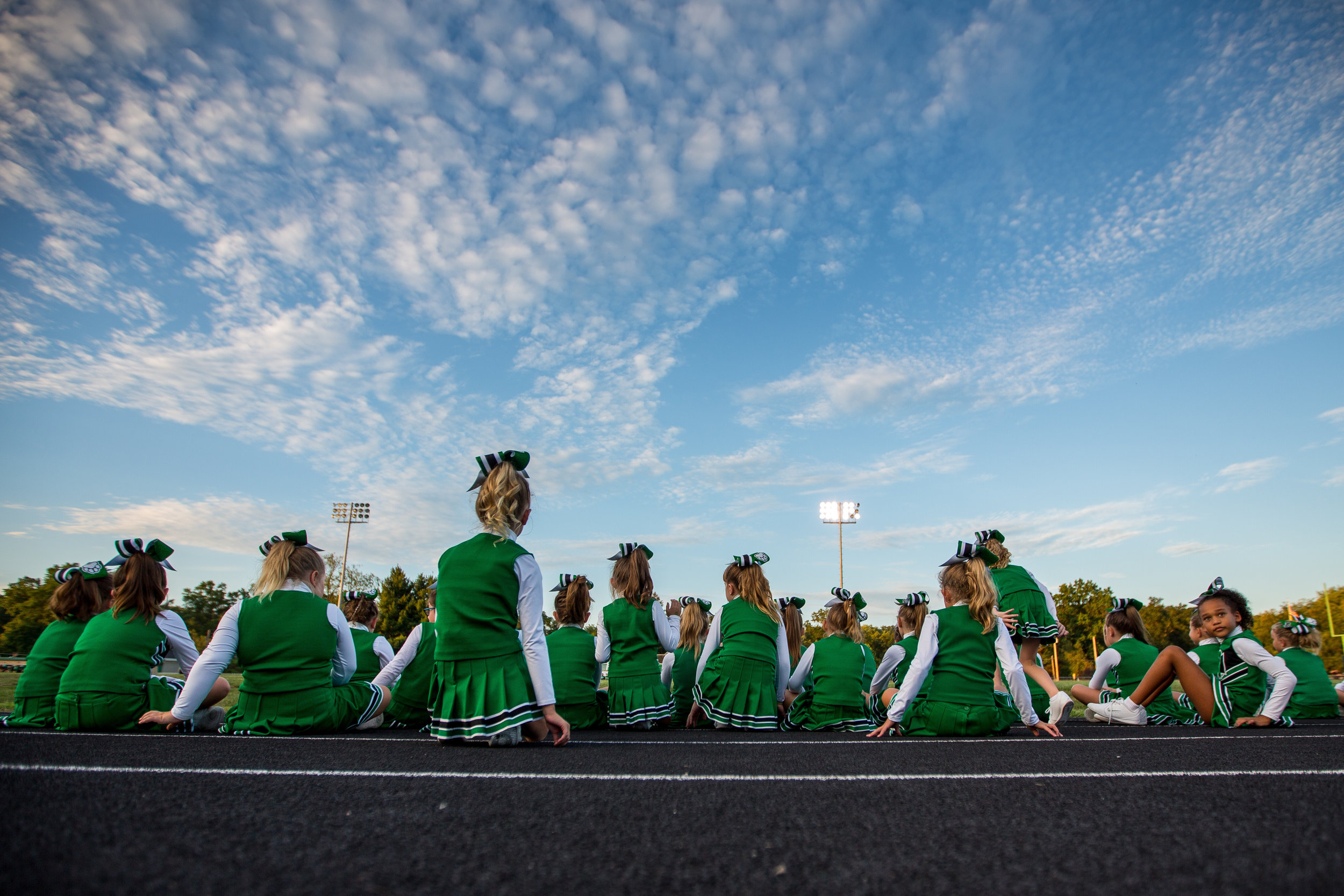  Participants of Twerp Cheer sit on the track while watching other cheerleaders perform at Riverside High School's Meet the Panthers pep rally on Thursday evening.  