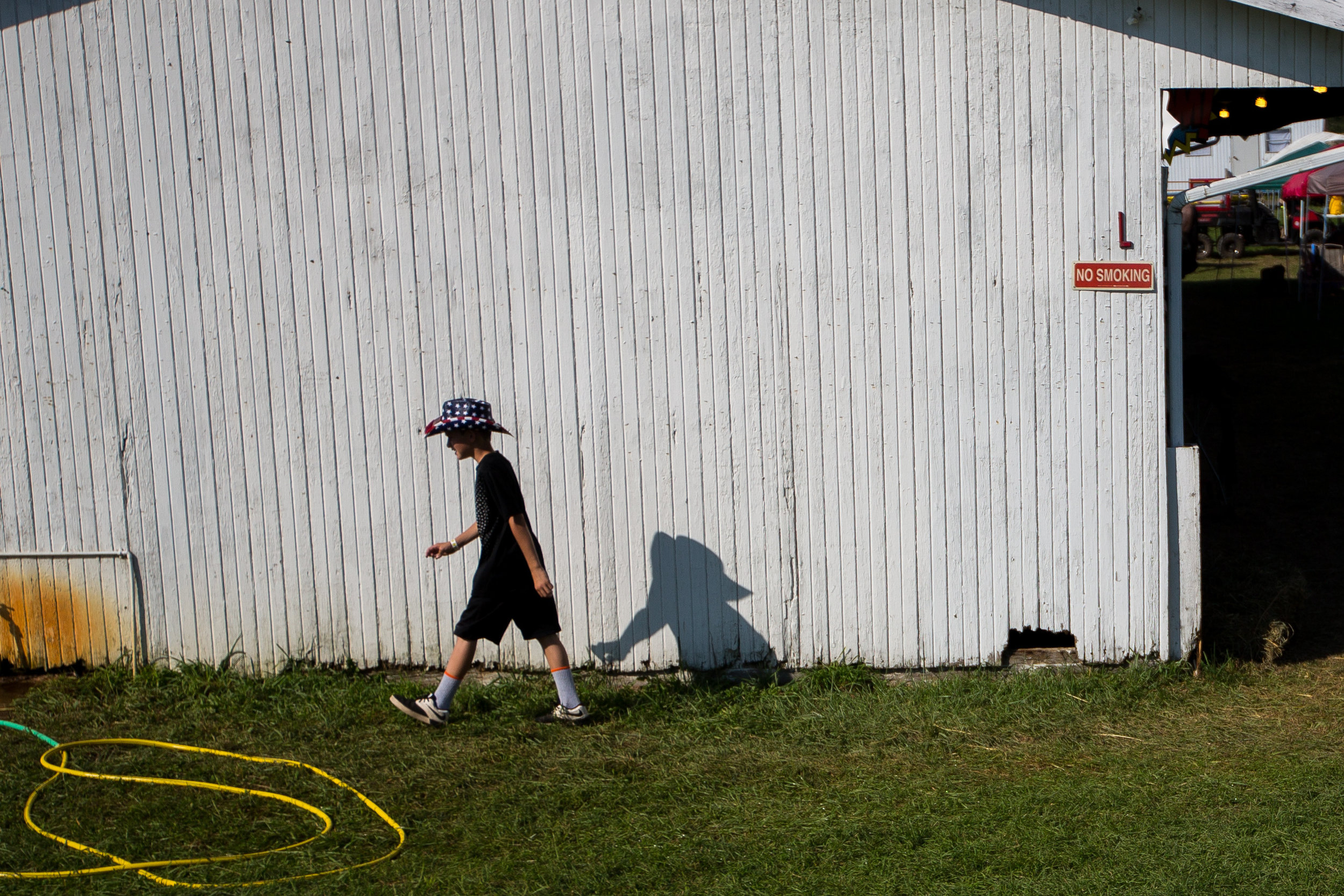  Trent "Beanz" Gurrieri, 11, walks past a barn at the Hookstown Fair in Hookstown on Saturday evening.  