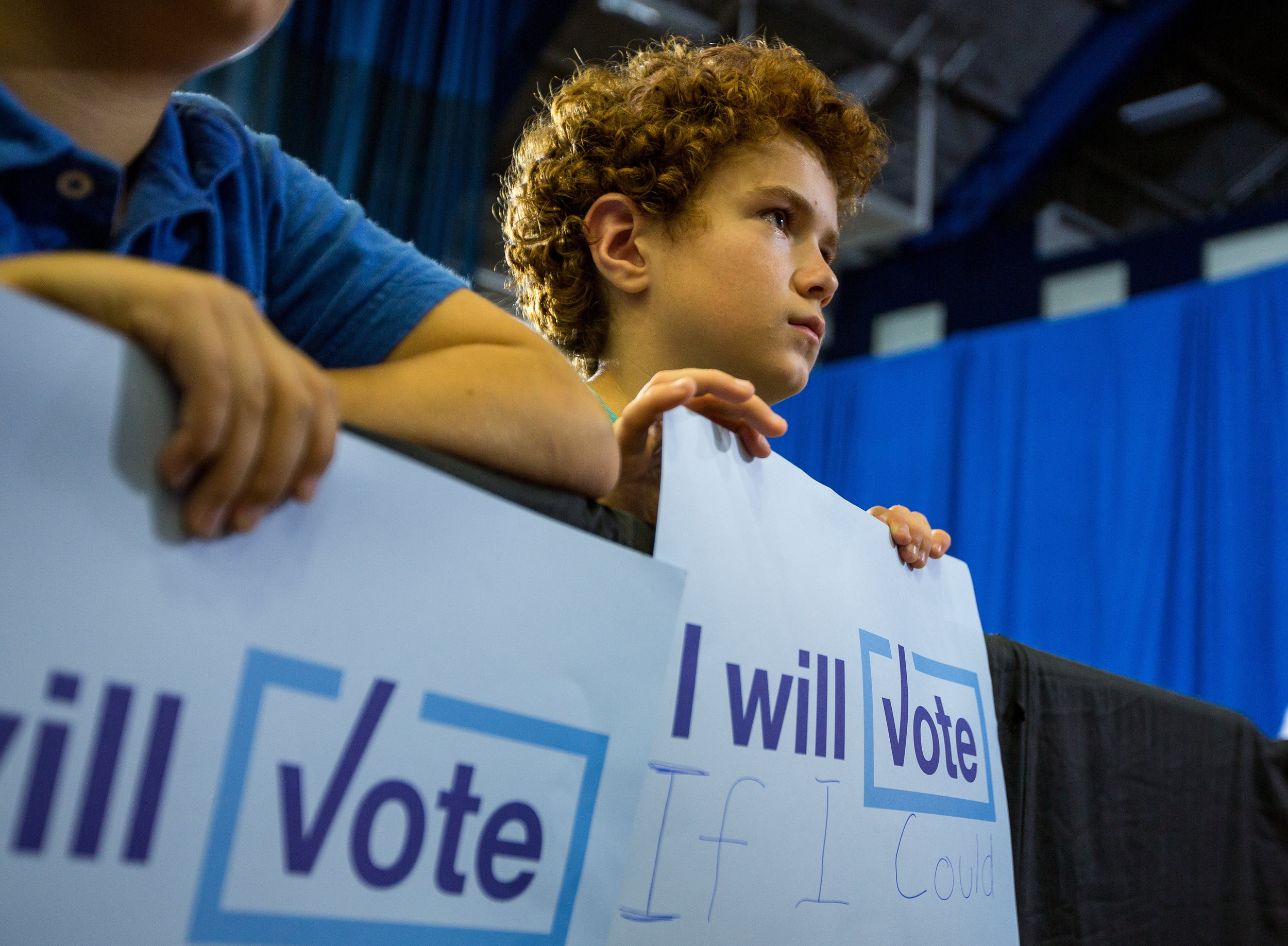  A young boy holds a sign reading, "I will vote if I could" during First Lady Michelle Obamas speech at the Fitzgerald Field House at the University of Pittsburgh on Wednesday afternoon. First Lady Michelle Obama showed her support for Democratic pre