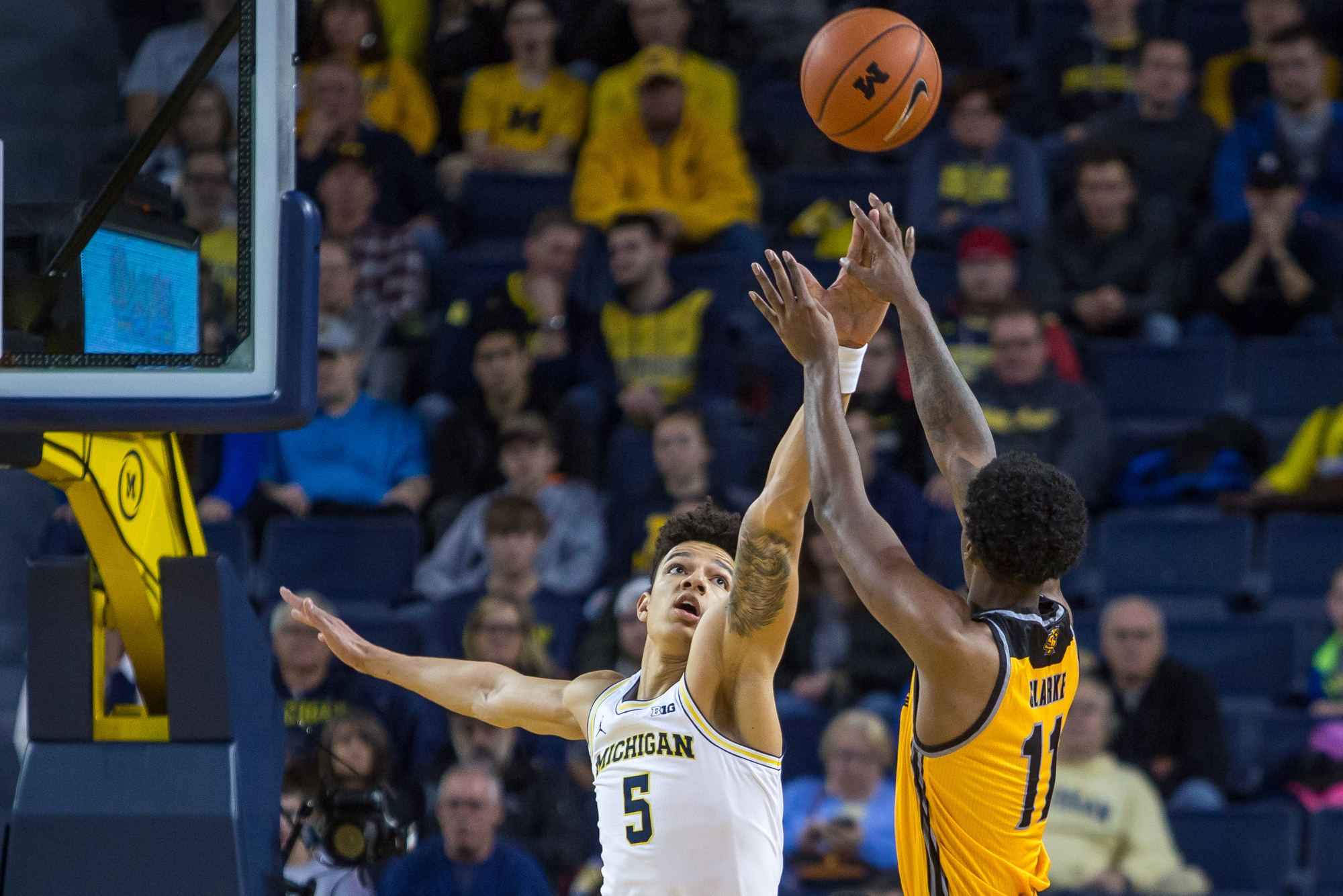  Michigan�s D.J. Wilson (5) attempts to block Kennesaw State's Kyle Clarke (11) during the first half of play against Kennesaw State at the Crisler Center on Saturday, December 3, 2016. Michigan leads Kennesaw State 47-29 at half time. Matt Weigand |