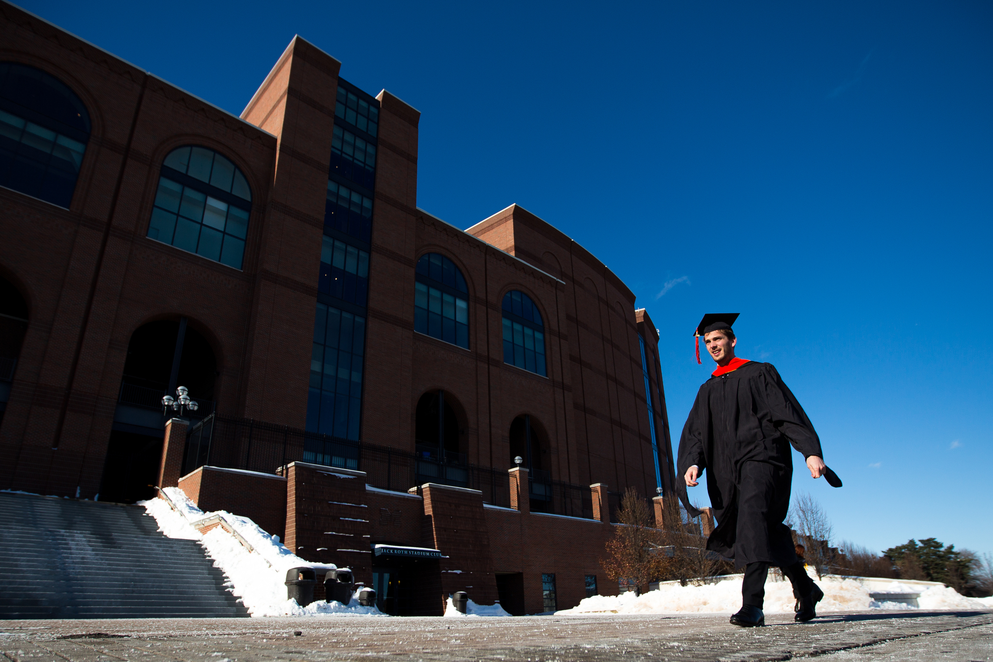  Florian Jule, graduating with a masters of science in aerospace engineering, walks past Michigan stadium before the University of Michigan winter commencement on Sunday, December 18, 2016. Jule and about 1,000 other students graduated at the Crisler