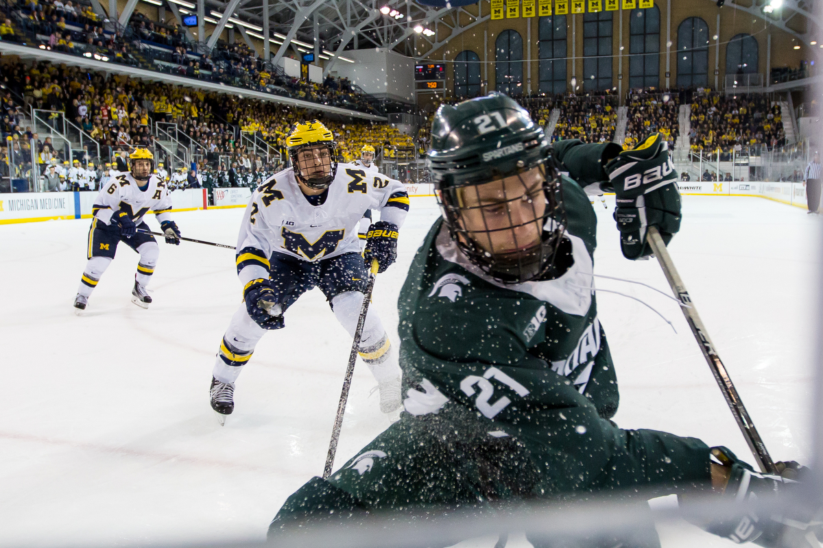  Michigan State's Joe Cox (21) skates after the puck with pressure from Michigan's Luke Martin (2) at Yost Ice Arena on Saturday, February 11, 2017. The Michigan State Spartans beat the University of Michigan Wolverines 4-1. Matt Weigand | The Ann Ar