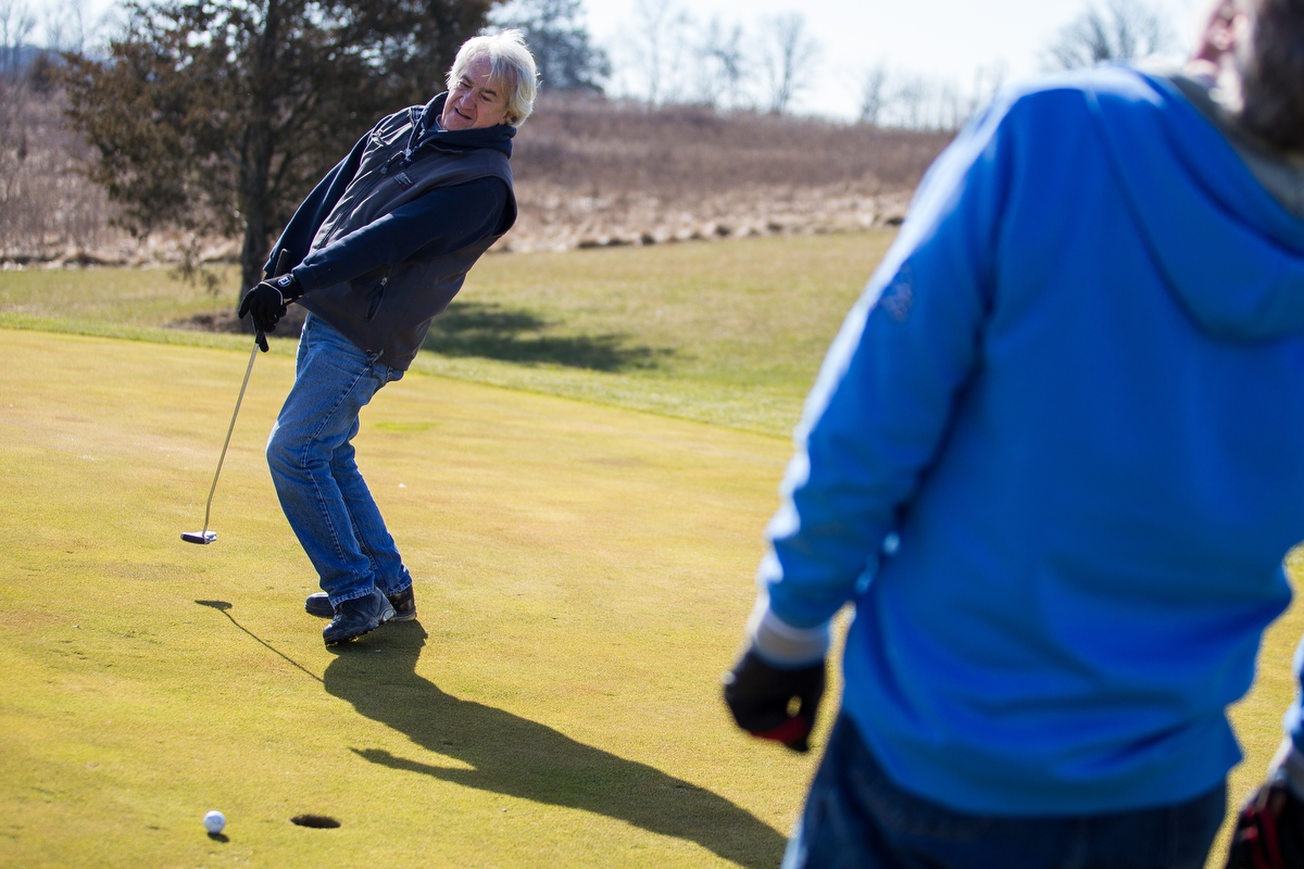  Leon Dillon, left and Rick Polmounter react after Dillon misses a putt on the 15th green while golfing at Rustic Glen Golf Club in Saline on Friday, February 16, 2017. Due to the unseasonably warm weather, local golf courses are beginning to open fo