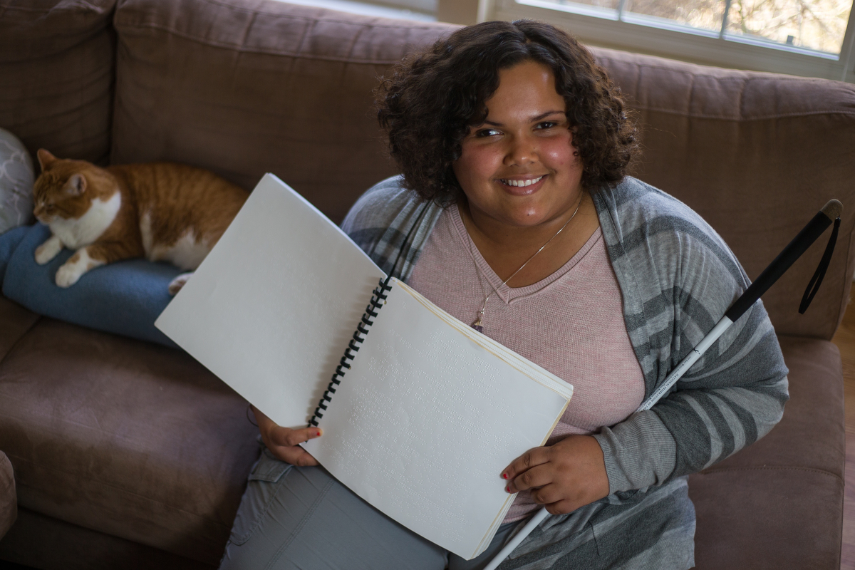  India West, a senior at Clonlara Academy in Ann Arbor, poses for a photograph with her cat Jazmine in her Ypsilanti home on Thursday, February 23, 2017. West, who is legally blind, is hoping to raise money, half from the Bureau of Services for Blind