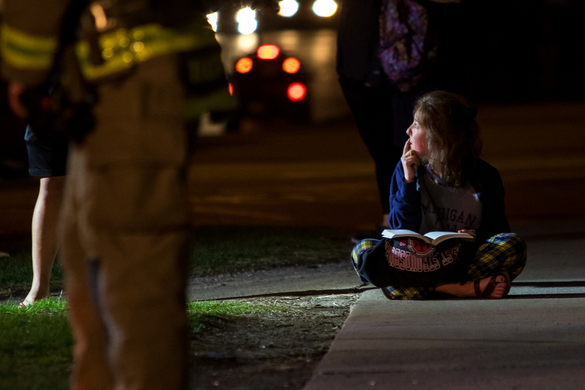  Meredith Mcphail, first year law student at the University of Michigan, studies outside of her apartment building at 607 Hill St. after a small fire was called to the Ann Arbor Fire Department at 8:13 p.m. on Monday, March 27, 2017. The fire was con
