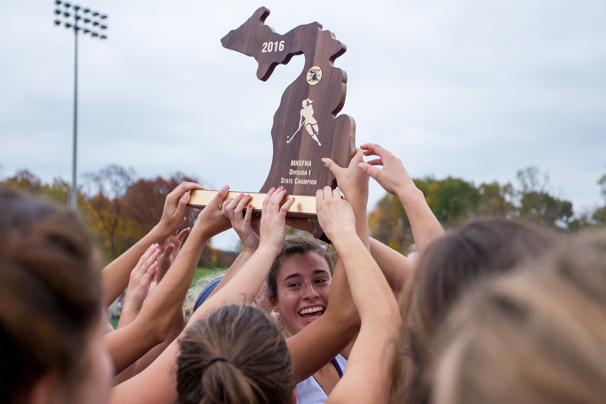  Players from Pioneer High School hold up the MHSFHA Division I State Championship trophy after their win in the D1 State Field Hockey Championships against Dexter High School at Skyline High School on Saturday, October 29, 2016. Pioneer beat Dexter 