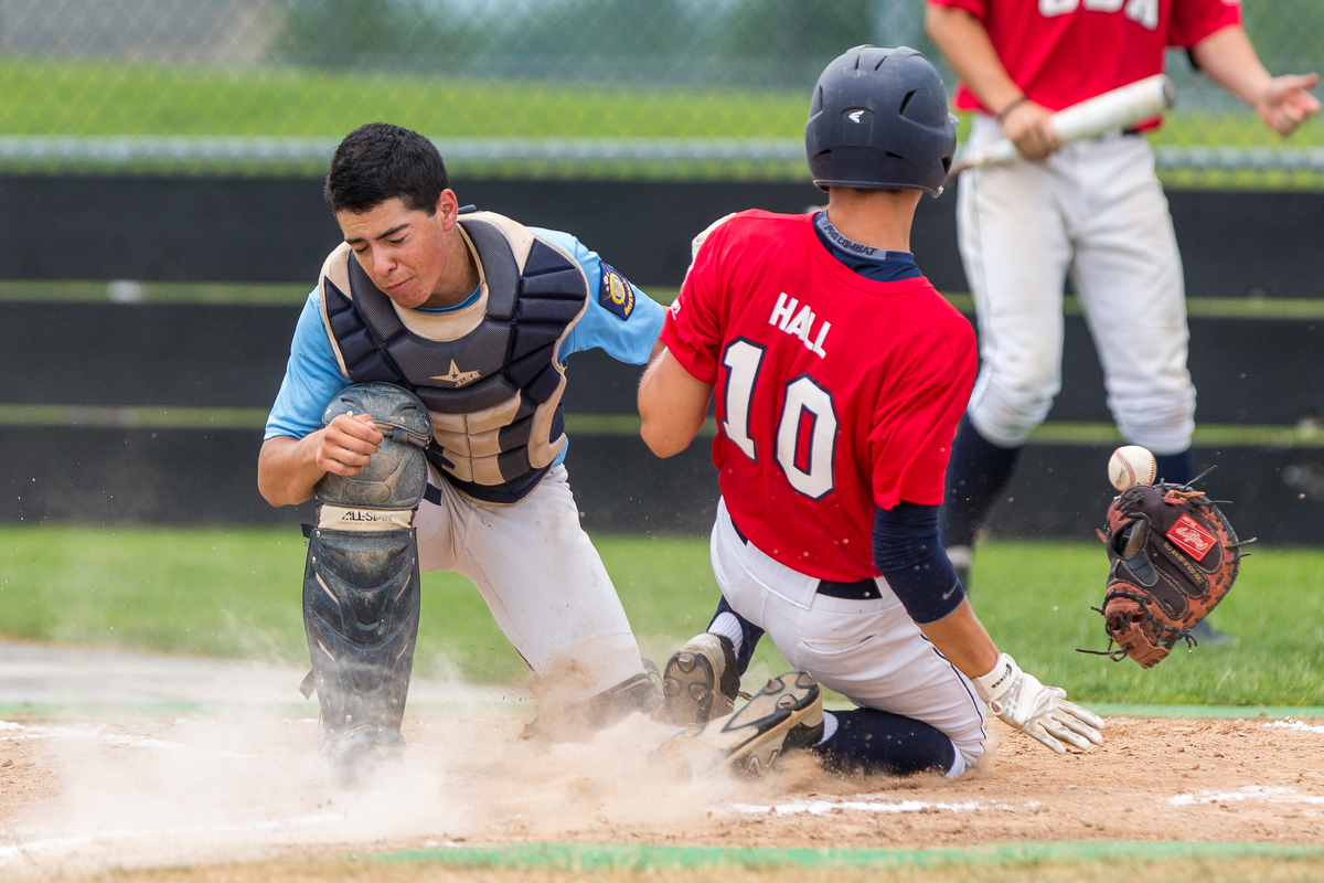  Jarrett Plunkett loses his glove while Jarred Hall slides into home during the first inning on Monday June 29, 2015. The Coeur d'Alene Lumbermen scored three runs during the first inning at Post Falls High School.  