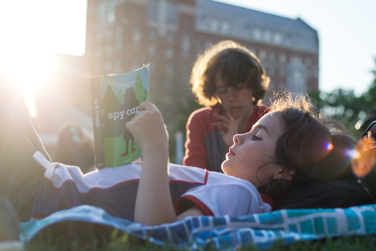  Levi Berg, nine, reads a book at Ingalls Mall for the opening night of Top of the Park, part of the Ann Arbor Summer Festival on Friday, June 9, 2017. The opening night featured yoga, multiple live music acts and food and drinks for all ages. Matt W