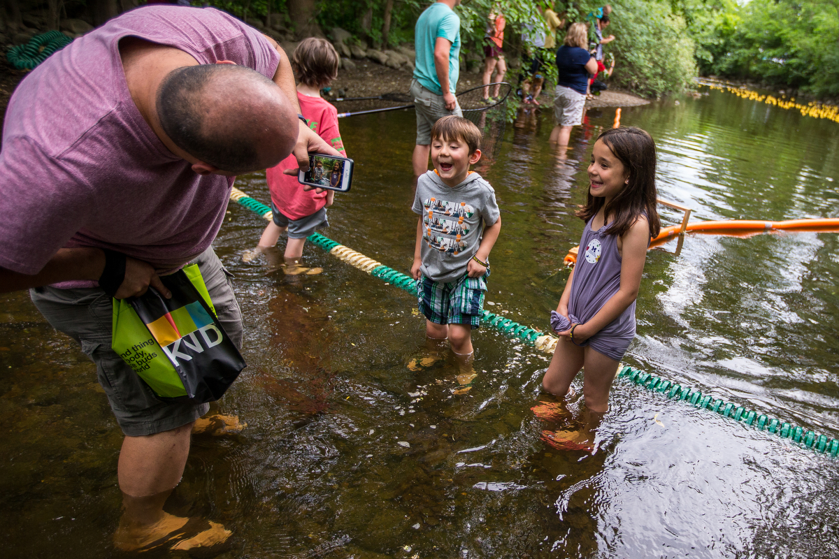  Fabian Salinas, left, takes a picture of his kids Remy, center, 5 and Esmie, 7, at the Huron River at Island Park during the rubber duck dash on Friday, June 16, 2017. The National Kidney Foundation of Michigan hosted the first annual event in order