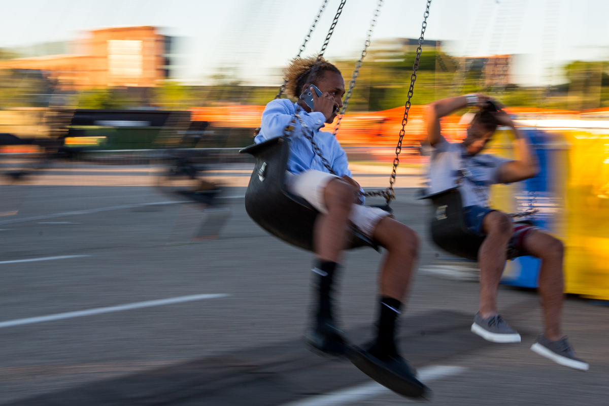  Elijah Beall talks on the phone while riding a ride during the opening day of the Ann Arbor Jaycees Carnival at Huron high School on Wednesday, June 21, 2017. The carnival runs from Wednesday to Sunday and over 30 rides and carnival games are availa