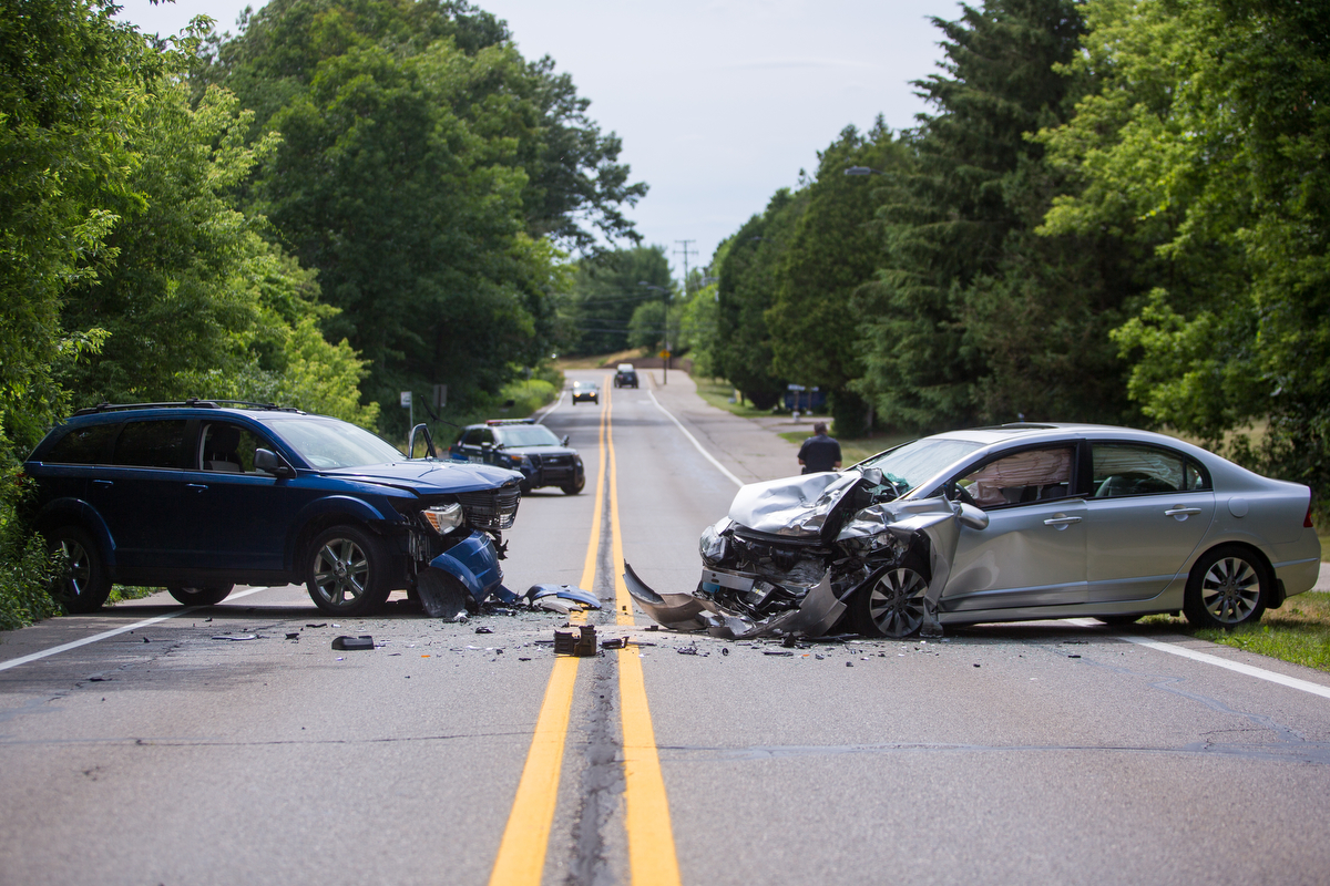  Two cars sit on Glazier Way, near the UMH Child Care Center, after a head on collision closed the road on Wednesday, June 28, 2017. The driver of the silver car swerved into the oncoming lane after looking at their GPS on their phone. Both drivers w