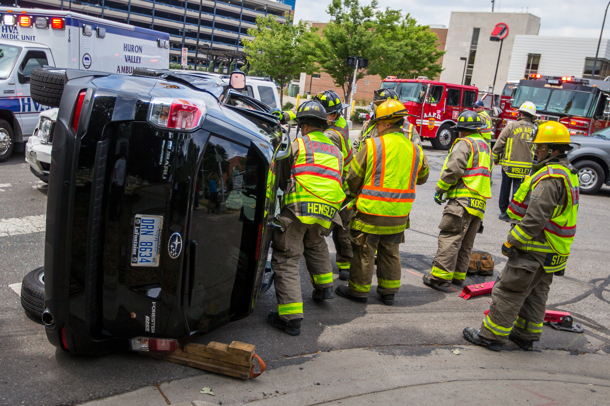  Members of the Ann Arbor Fire Department work to free two individuals from a Subaru after it was involved in a collision with a Jeep at the intersection of Fifth Avenue and East William Street on Thursday, June 29, 2017. There were no major injuries