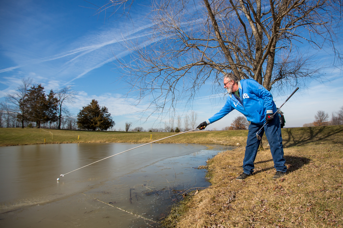  Rick Polmounter reaches for a ball that sits on the ice while golfing on the 15th hole at Rustic Glen Golf Club in Saline on Friday, February 16, 2017. Due to the unseasonably warm weather, local golf courses are beginning to open for golfing. Matt 