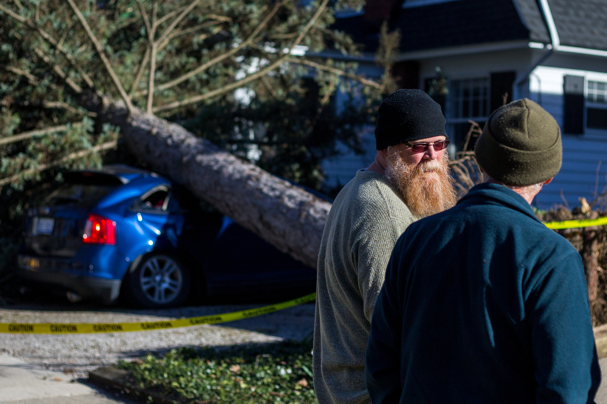 Homeowner Phillip Cartman, left, talks with neighbors after a large tree sits on the top of a car belonging to a nanny at Cartman's neighbors house near the corner of Packard Street and Granger Ave. after being toppled by high winds on Wednesday, Ma