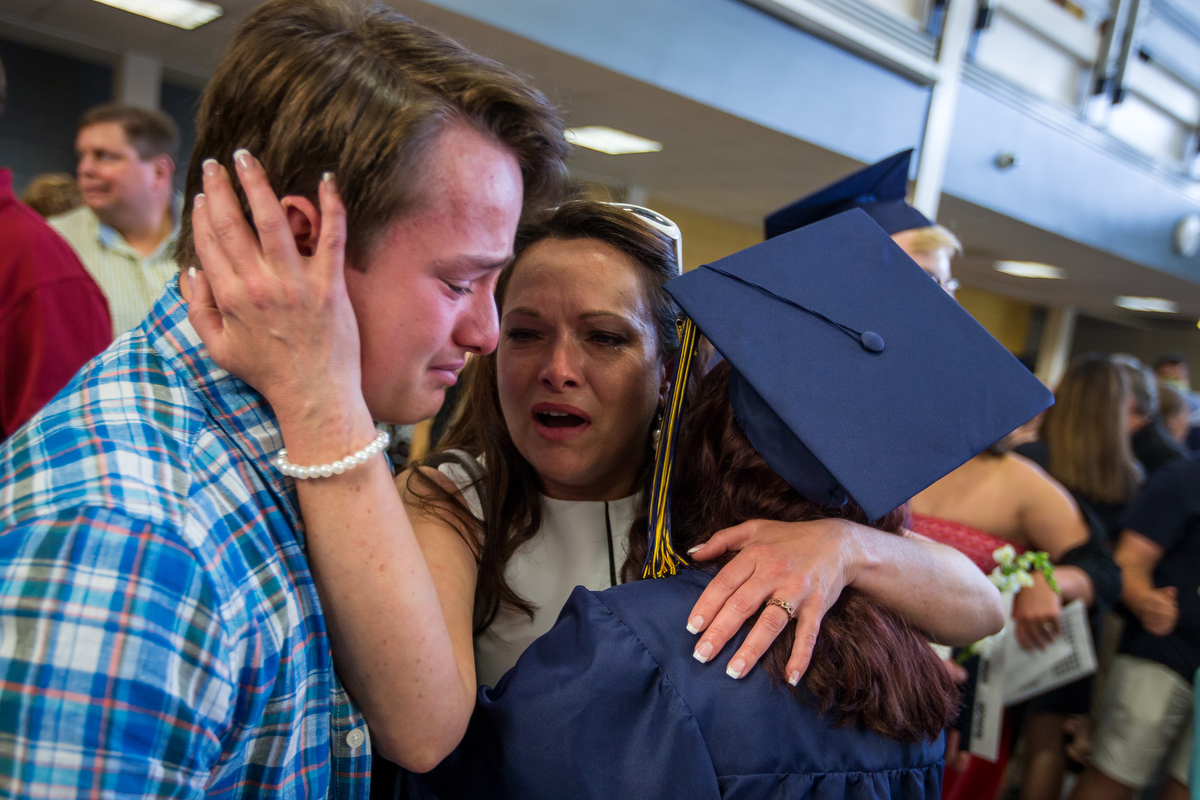  Sean Egan, left and Sandy Werth cry as they embrace Oak Marie Egan after the graduation ceremony at Chelsea High School on Sunday, June 4, 2017. Matt Weigand | The Ann Arbor News 