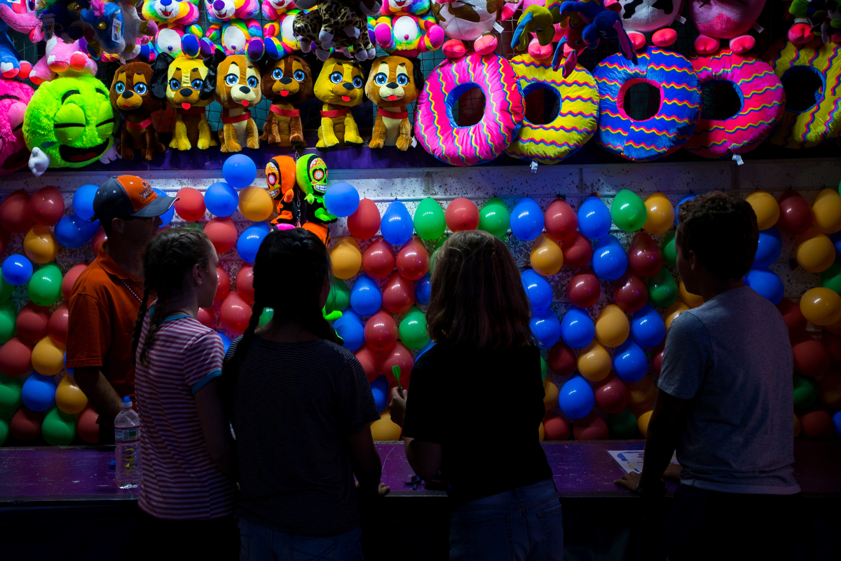  A group of people play a carnival game during the opening day of the Ann Arbor Jaycees Carnival at Huron high School on Wednesday, June 21, 2017. The carnival runs from Wednesday to Sunday and over 30 rides and carnival games are available for all a