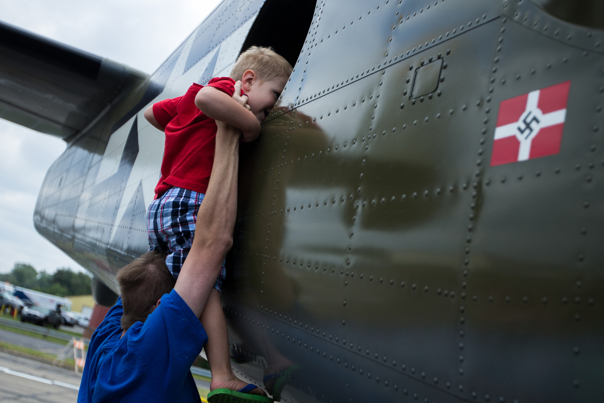  Joshua Dedinsky holds up his son Logan, 2, to look inside of an airplane at the Thunder Over Michigan Air Show at Willow Run Airport on Sunday, September 3, 2017. Matt Weigand | The Ann Arbor News 