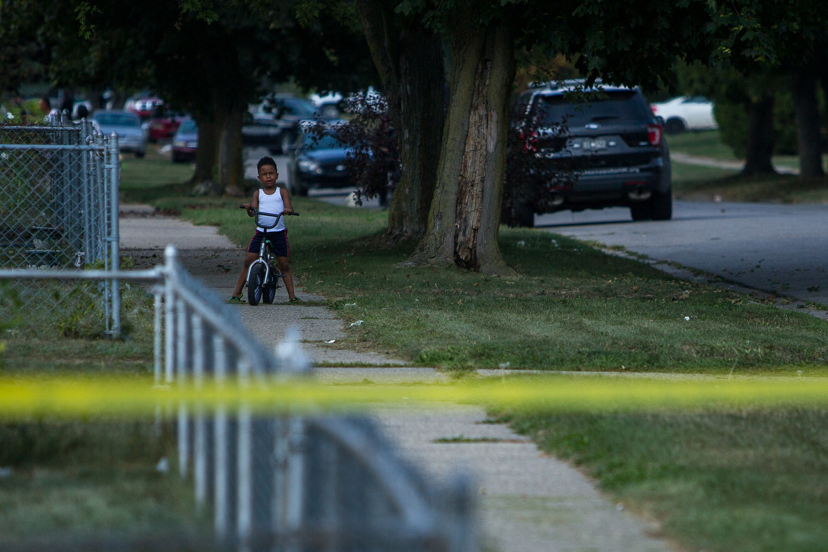  A young boy rides his bike as members of the Washtenaw County Sheriff department investigate a shooting was reported near 1366 Nash Avenue in the West Willow neighborhood on Monday, September 25, 2017. The incident is under investigation. Matt Weiga