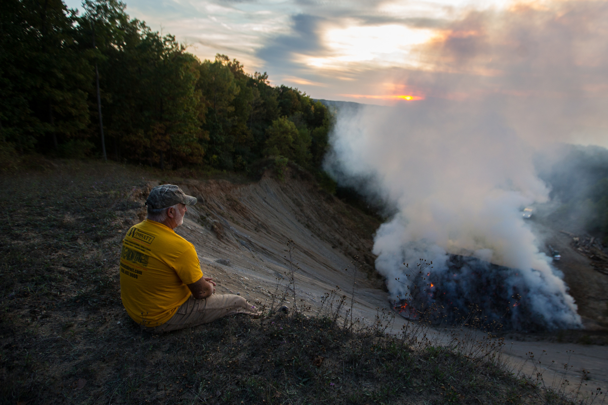  Barry Boyes watches as a large pile of wood chips burns along Toma Road in Dexter on Monday, October 2, 2017. The cause of the fire is not known, but it is expected to burn for days. Matt Weigand | The Ann Arbor News 