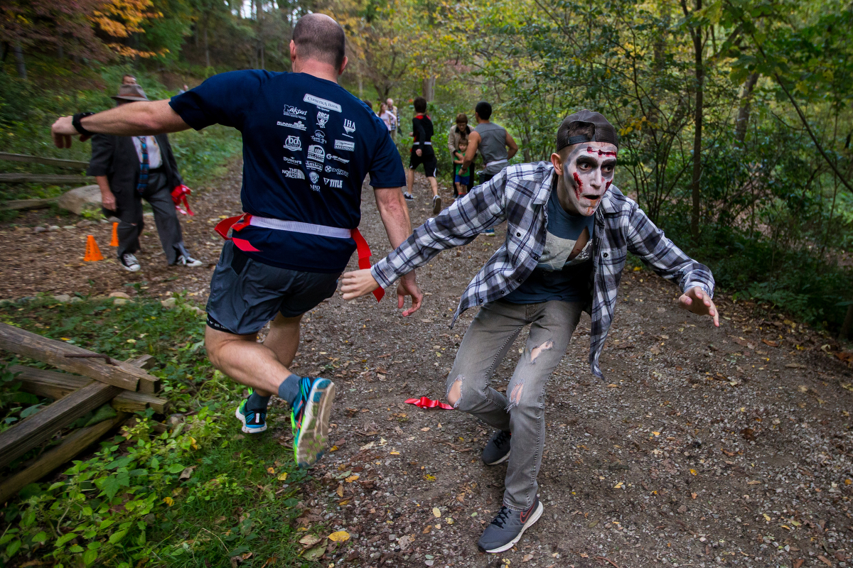  Joey Markell chases runners at Nichols Arboretum for the first Zombie Run 2017 on Friday, October 13, 2017. The run was a 5K where participants ran with "life" flags and about 50 zombies were hidden throughout the course attempting to take the flags