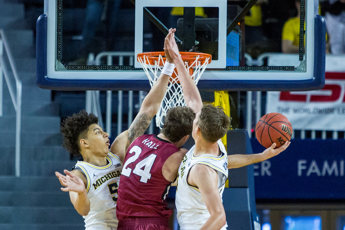  Michigan�s D.J. Wilson (5), left and Michigan�s Mark Donnal (34) foul IUPUI's Evan Hall (24) during the second half of play against IUPUI at the Crisler Arena on Sunday, November 13, 2016. The Michigan Wolverines beat the IUPUI Jaguars 77-65. Matt W