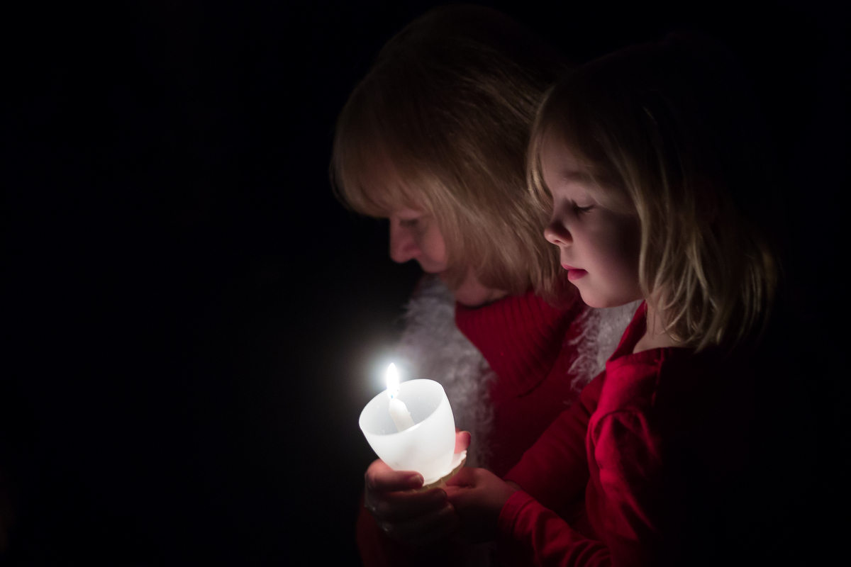  Two churchgoers worship during a candlelit service at Vineyard Church of Ann Arbor worship under candlelight on Saturday, December 24, 2016. Church volunteers delivered 100 dozen donuts from Washtenaw Dairy to people all over the Ann Arbor area who 