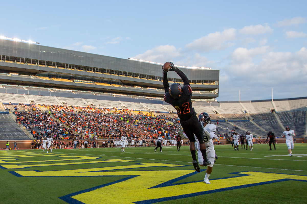  Belleville's Julian Barnett, 12, makes a jumping catch for a touchdown during the opening game of Battle at the Big House at Michigan Stadium on Thursday, August 24, 2017. The Belleville Tigers beat the Brighton Bulldogs 34-31 in overtime.  