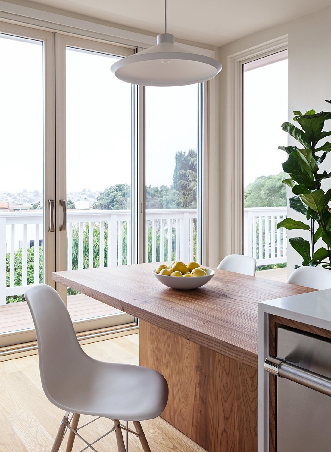 floor-to-ceiling-windows-brighten-the-small-footprint-custom-elm-wood-table-by-kaimade 2.jpg