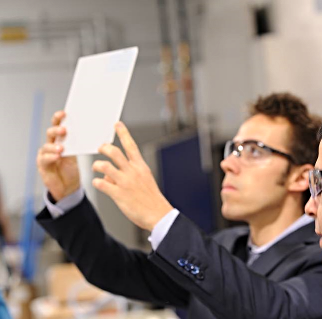 Glenn Jocher inspecting 10-micrometer multichannel plate prototypes at Incom's LAPPD manufacturing facility, 2014.