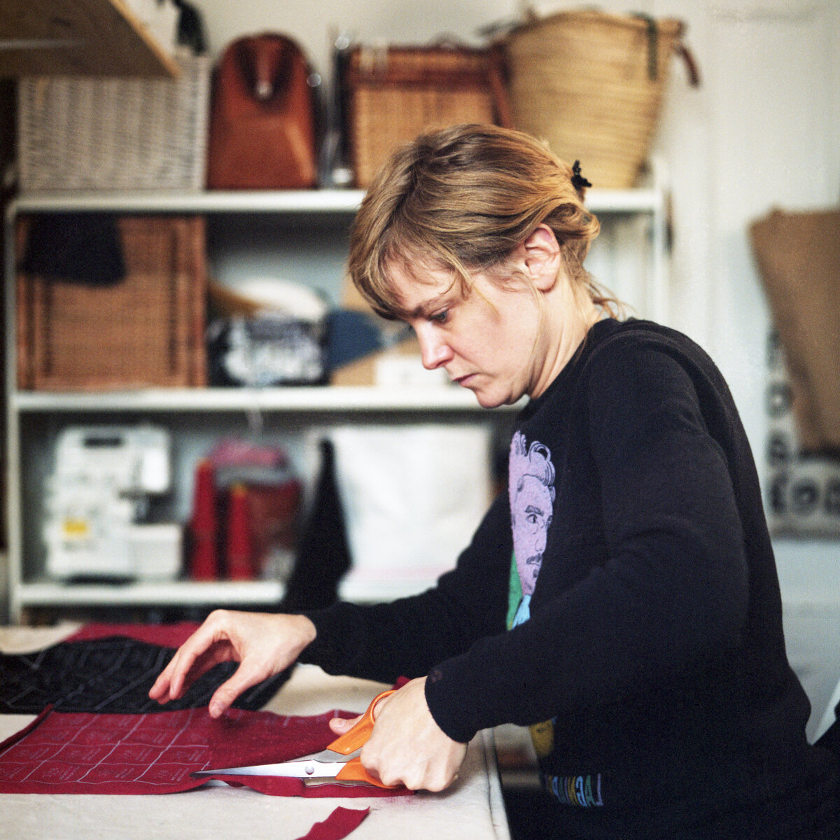 Clothing designer Perrine Hurrel (Bunny and Claude) cuts red and black undergarments in her home studio in Montréal, Canada.