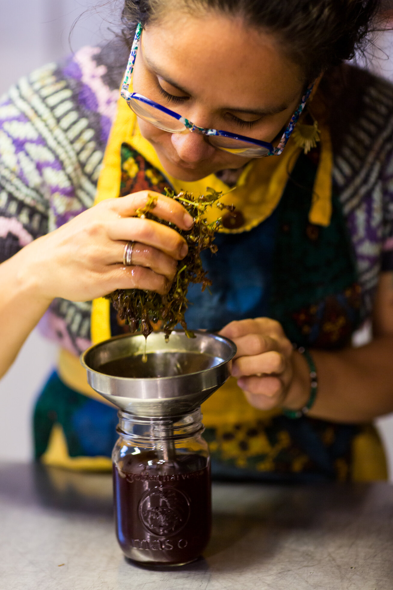 Celia Jimenez (Cucamanga) pours off red Saint John's Wort oil extract collected in the Canadian Laurentian forest.
