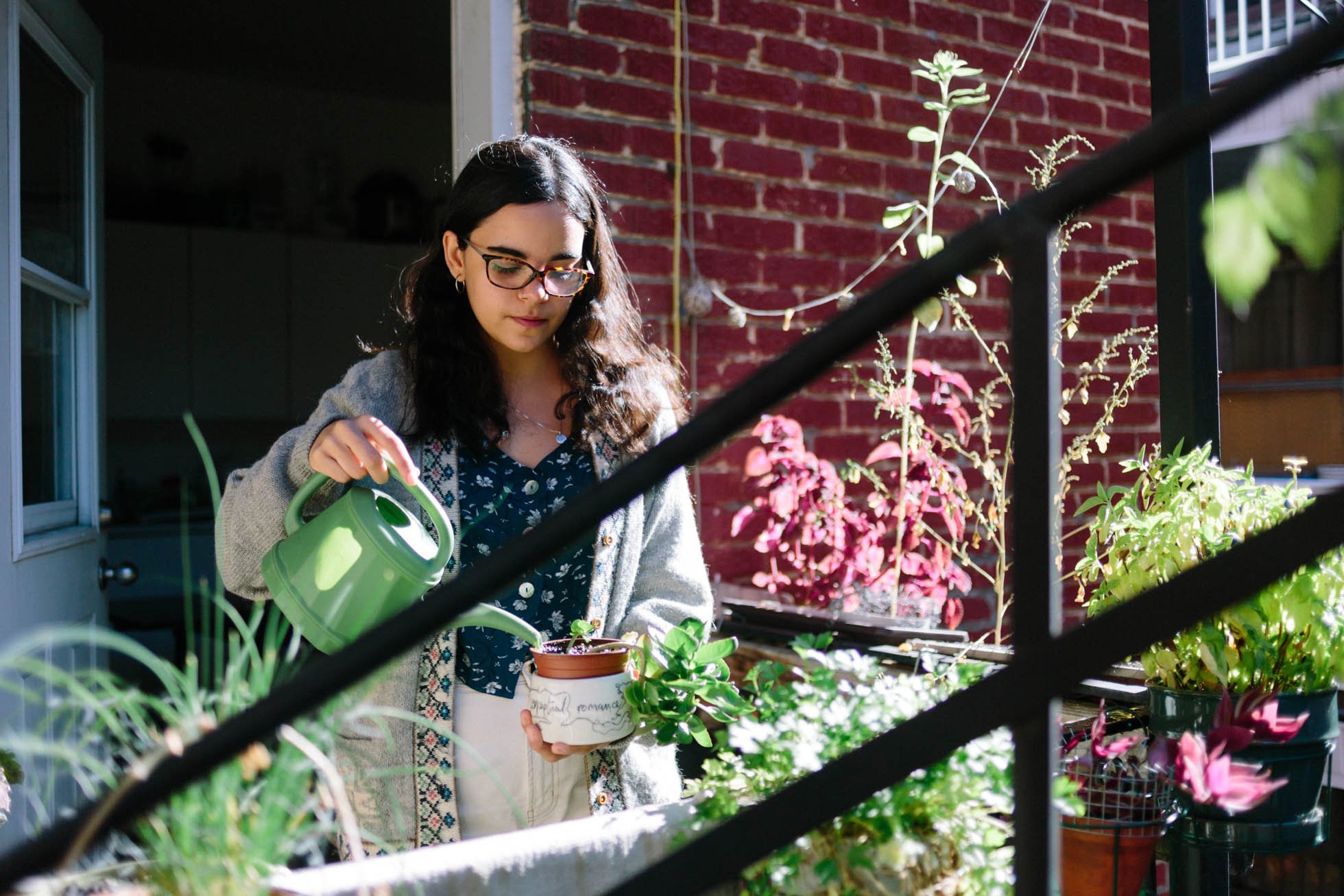  Hashmita uses a green watering can to water a small plant on her balcony garden. In classic Montréal fashion, Hashmita's balcony is tiny, barely 3 feet by 5 feet, but she's been able to do a lot with such a small space. While some might leave this s