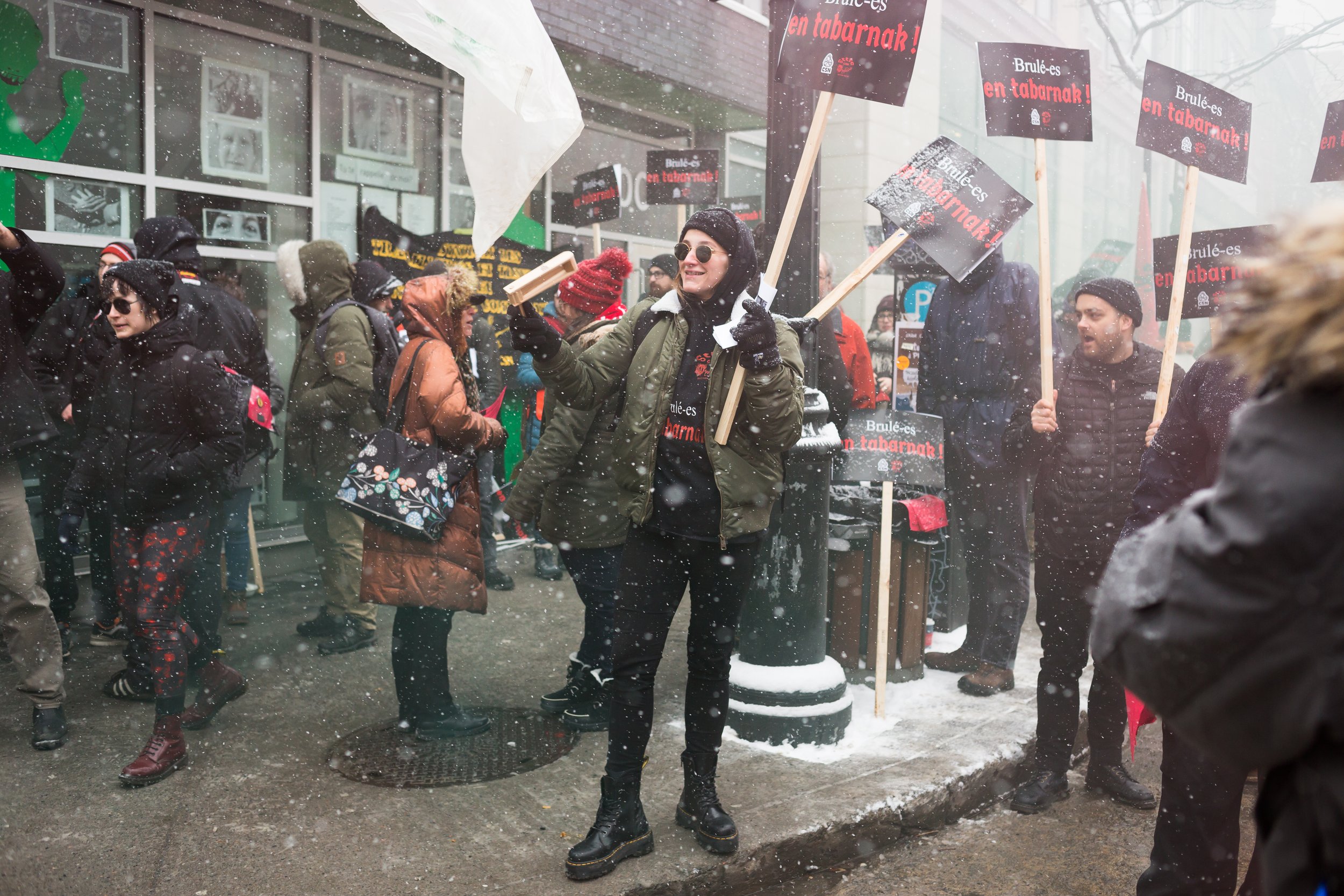  Laurence Fortin uses a wooden noisemaker on a STTIC-CSN picket line outside Cactus on December 18, 2019. (Briarpatch 2019) 