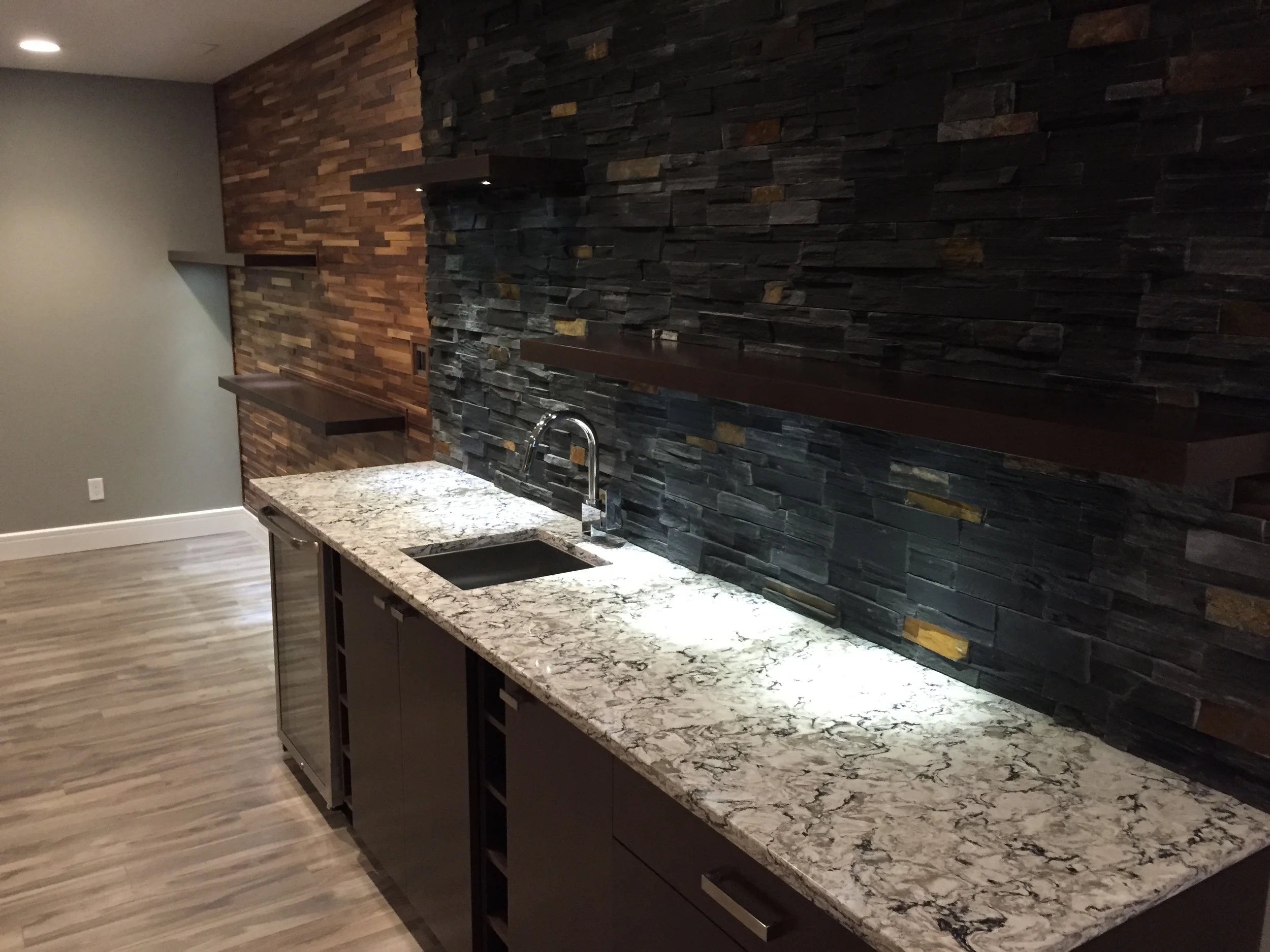 Basement renovation saskatoon, wet bar, stone work, custom shelves, trusted contractor.