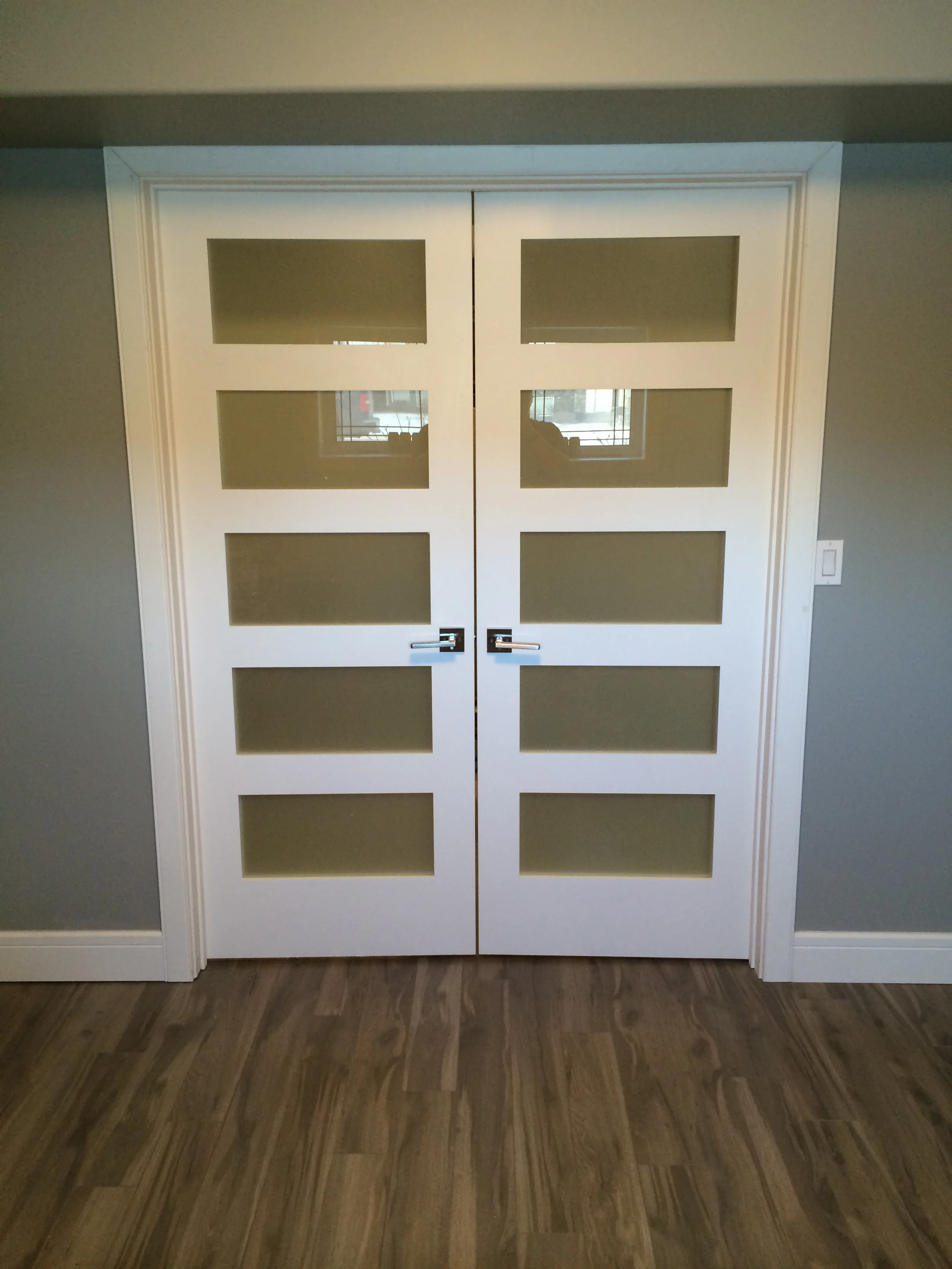 Basement renovation Saskatoon, bedroom, custom french doors, trusted contractor