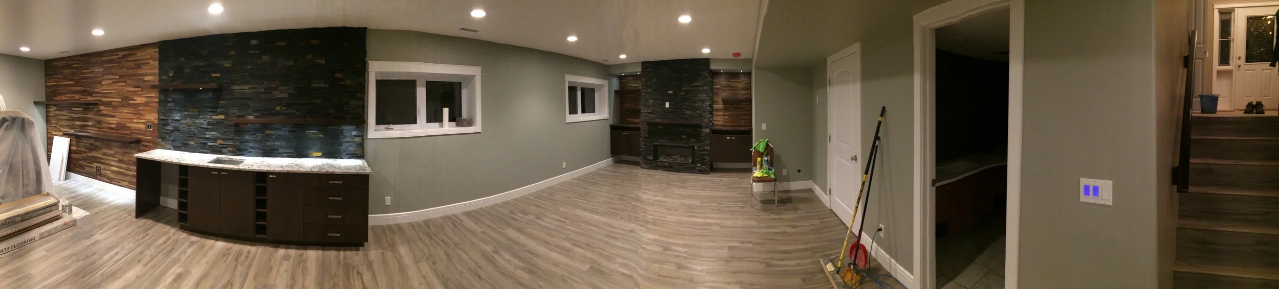 Basement renovation saskatoon, flooring, fireplace, stone work, custom shelving, trusted contractor.