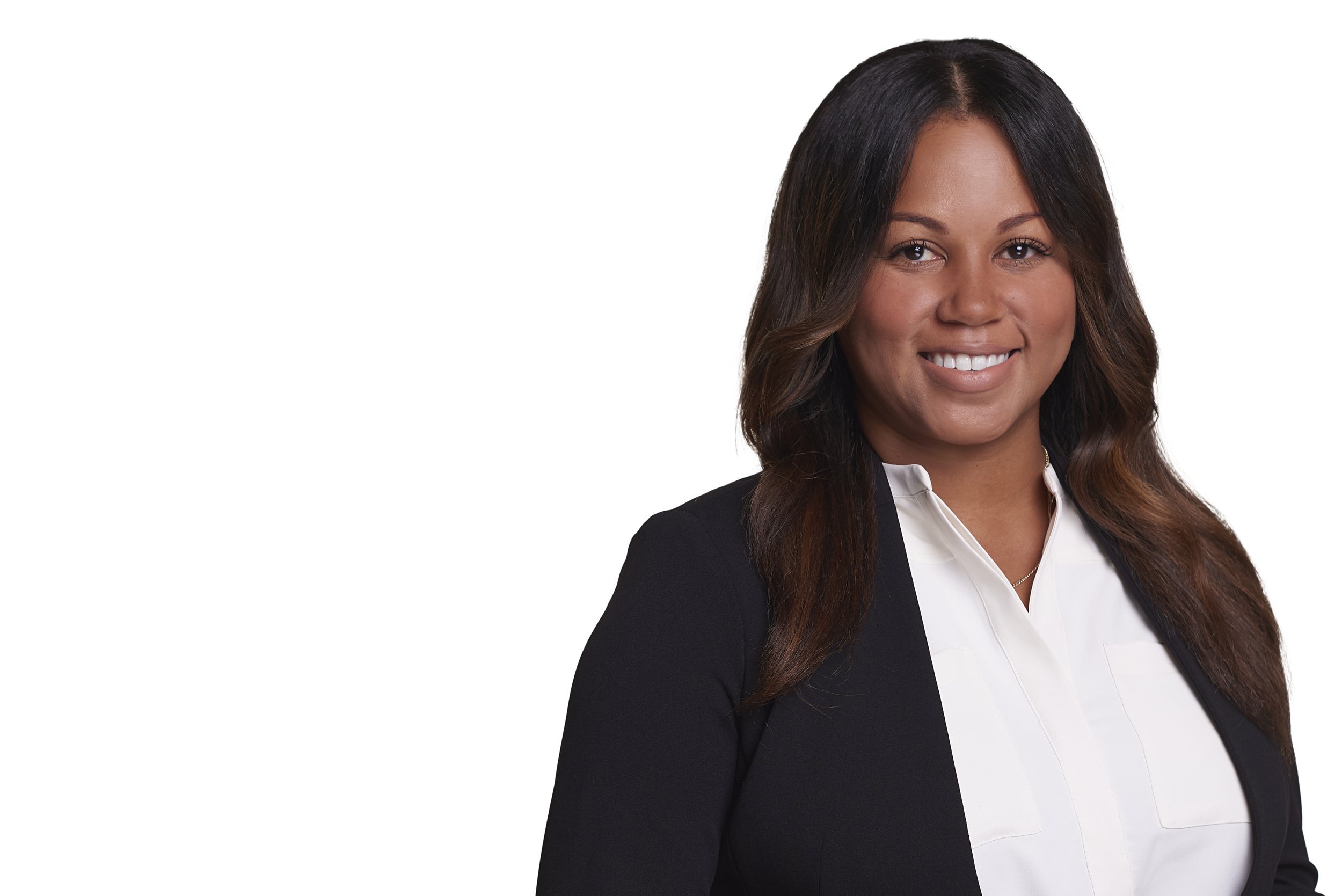 Professional woman with long dark hair smiling, wearing a black blazer and white blouse, against a plain white background.