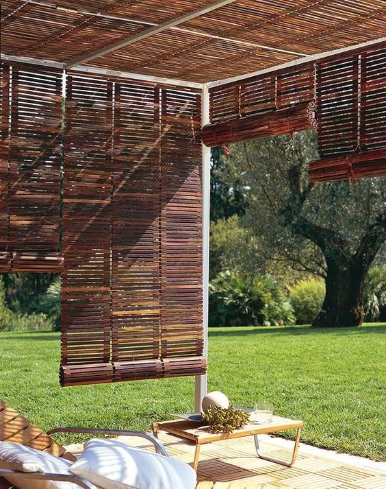 These wooden roll-up Venetian blinds are perfect to tie any patio in and make it its own individual space. Notice the wooden chaise lounges and deck tiles. Against the green grass (freshly cut!), it's like a little resort in your own backyard. Roll them up when you want to watch the kids toss the dog's frisbee or play with the Slip 'n' Slide (or when there's stormy weather). Roll them down when you want a little privacy and some shade from that hot, hot sun. 