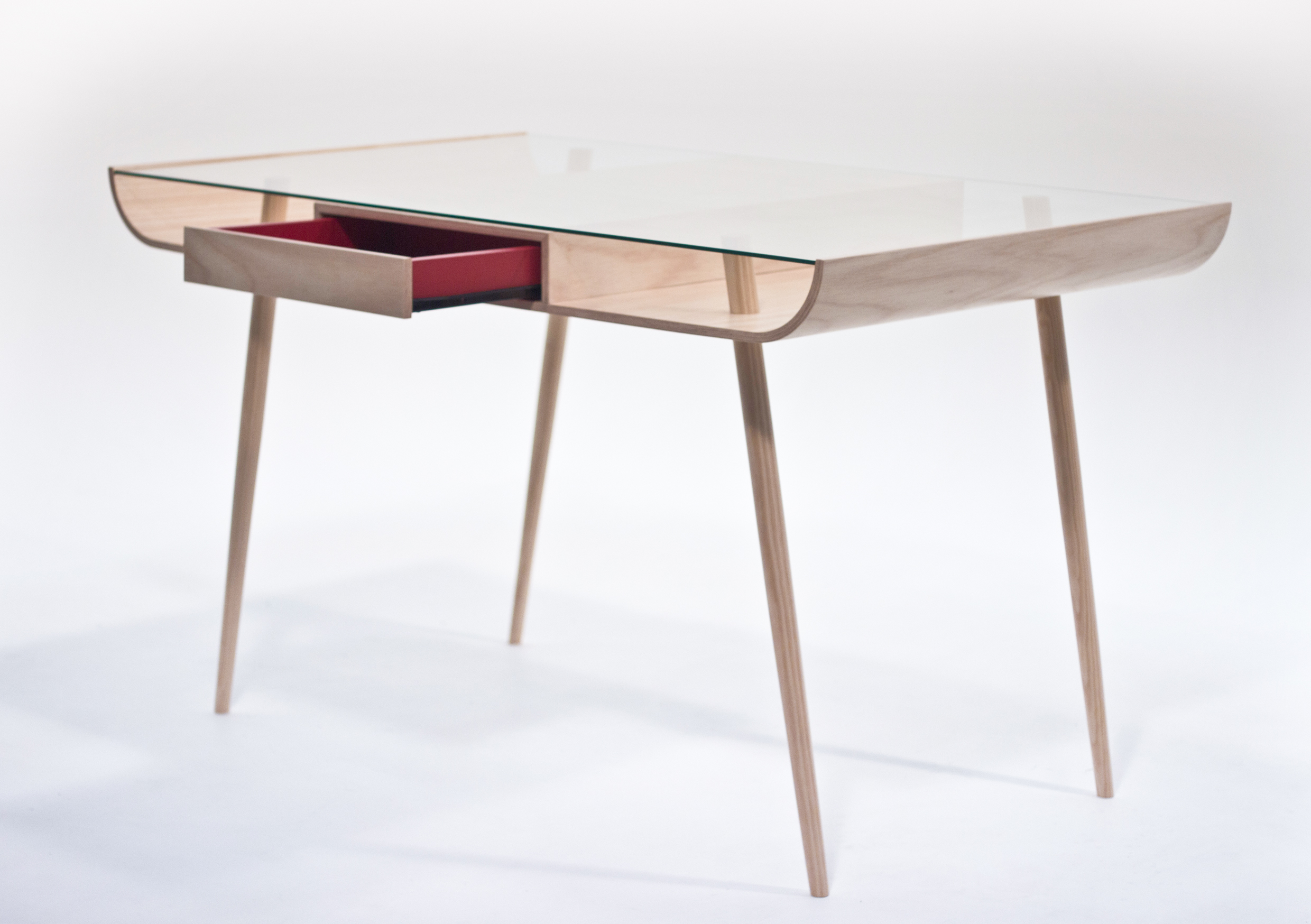 The two drawers were added to give a functional element in different environments. From dining tables and office desks to shop counters where a cash draw could be introduced, Leveillä is a multi purpose object that can adapt to users needs. The red accent is a way of adding a playful and surprising element to the design also tying it to other designs in this series ( Alpha ) The name Leveillä comes from the Finnish language translating in English to “show off”. Leveillä was designed so that the owner could display his/her own objects and artefacts underneath the glass top.