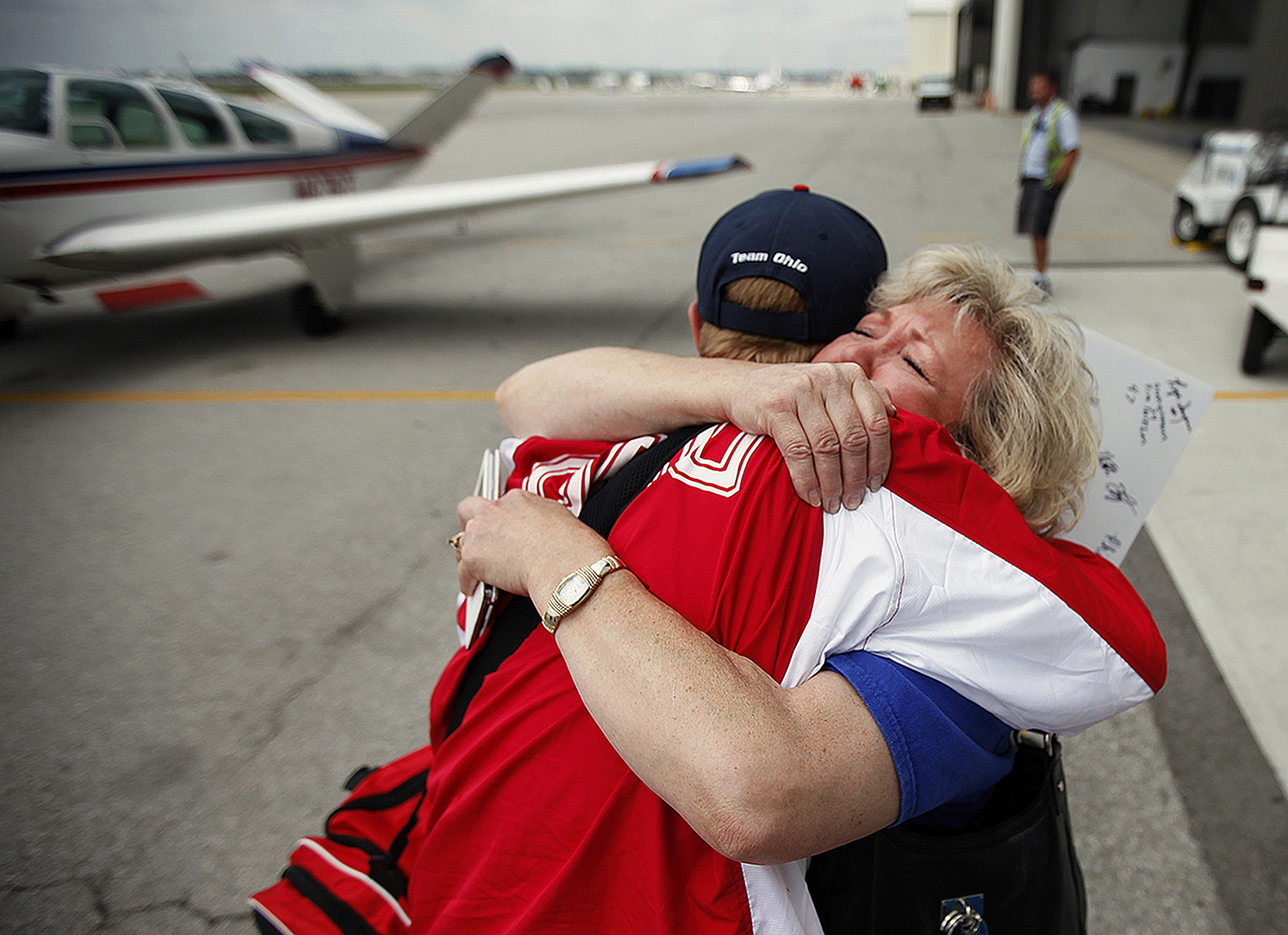 Cory Anatangelo, of Ohio's gold medal-winning Special Olympics softball team, embraces mother Pam Anatangelo, who sheds tears of joy as she welcomes him home from New Jersey, at the Lane Aviation terminal of Columbus International Airport in Ohio, Saturday, June 21, 2014. The softball team won a gold medal.