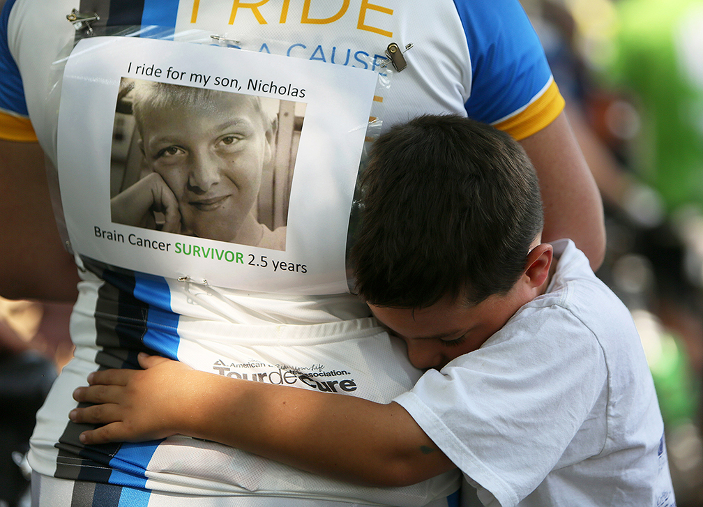 Matthew Sawchuk, 7, embraces his mother Jennifer Sawchuk, at the finish line of the Pelotonia 100-mile cancer awareness ride, Saturday, August 9, 2014, in Columbus, Ohio. Jennifer rode for Matthew's brother, Nicholas Sawchuk, 13, who is a two-and-a-half year survivor of brain cancer.