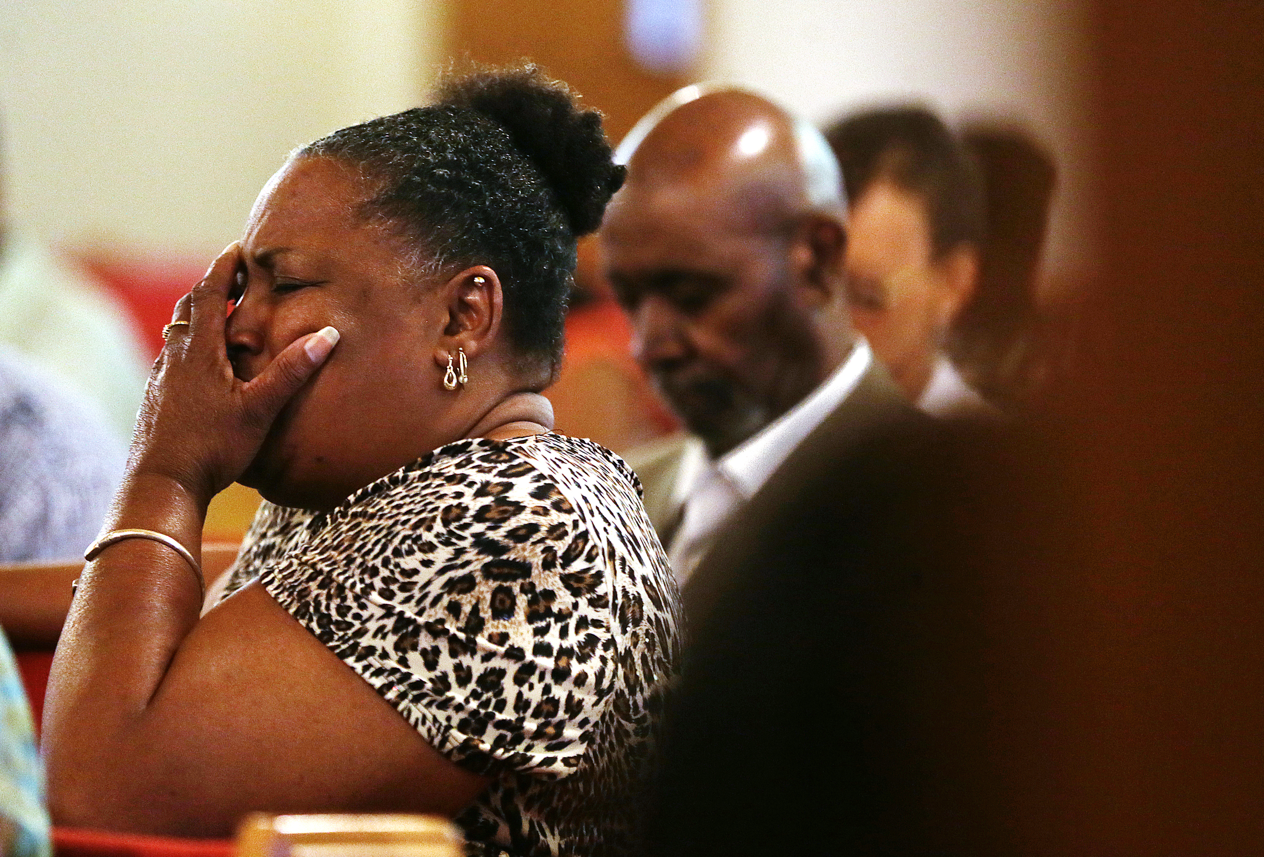 On the day following the Charleston church shooting in South Carolina, Bonnie Collins, of Brownsburg, Ind., holds her head in grief at the start of a vigil service held at St. John African Methodist Episcopal church for the shooting's victims, Indianapolis, Ind., June 18, 2015.