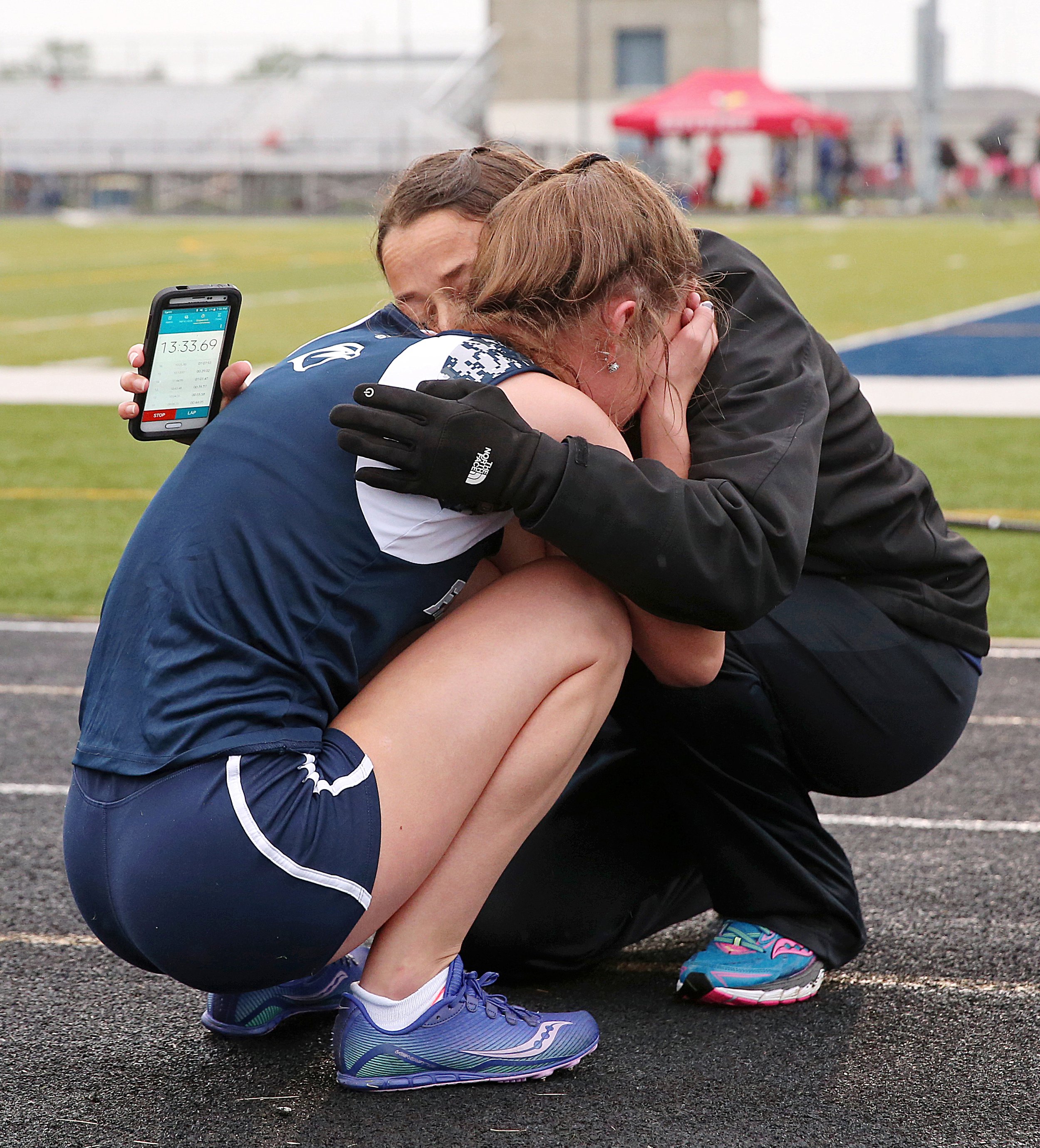  Perry Meridian's Kayla O'Brian is comforted by Perry Meridian distance coach Laura Schroeder at the finish line of the 3200 meter run, at the IHSAA girls track and field sectional at Decatur Central High School, Indianapolis, Tuesday, May 17, 2016. 